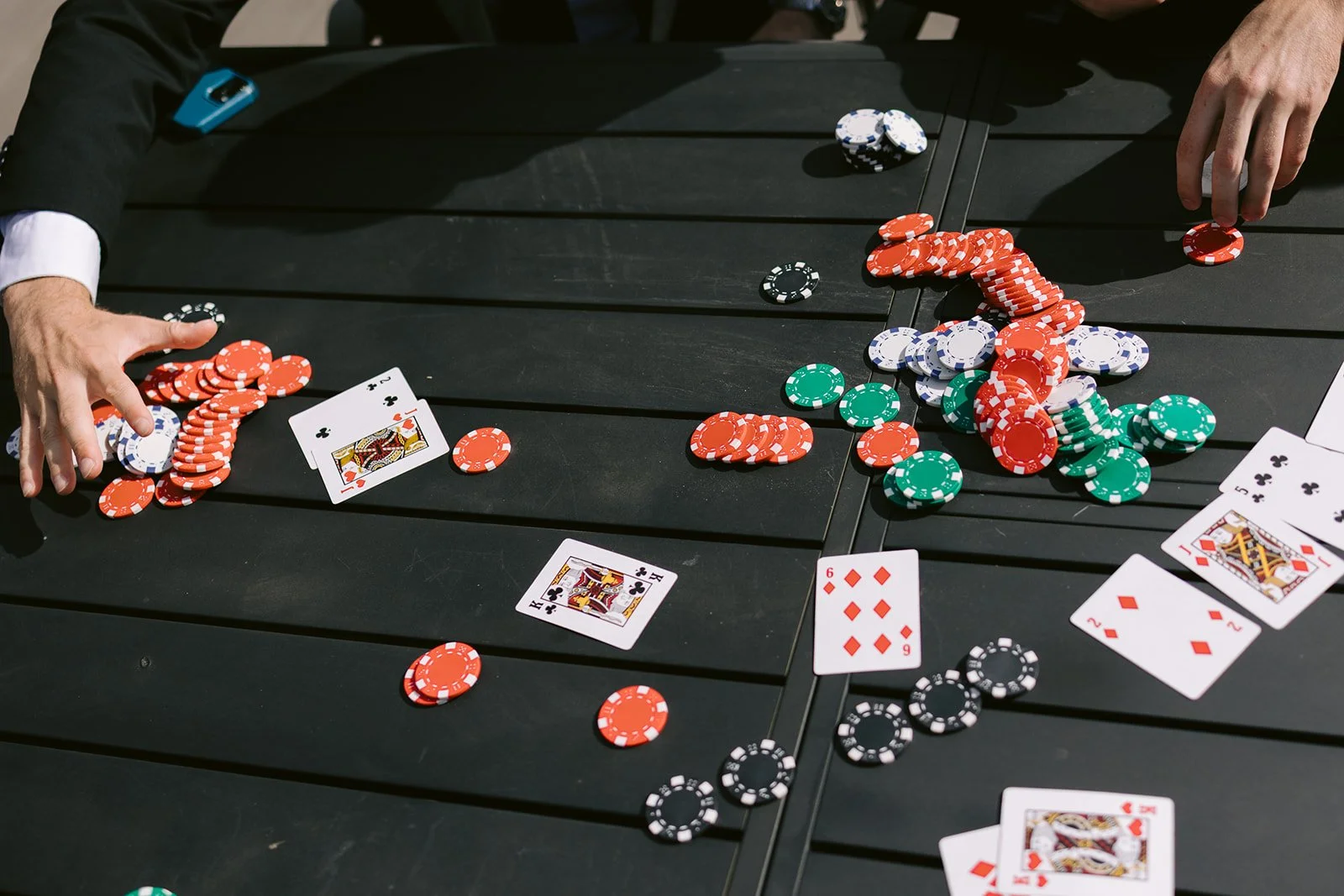 Poker chips and playing cards scattered across a table during a pre-ceremony card game