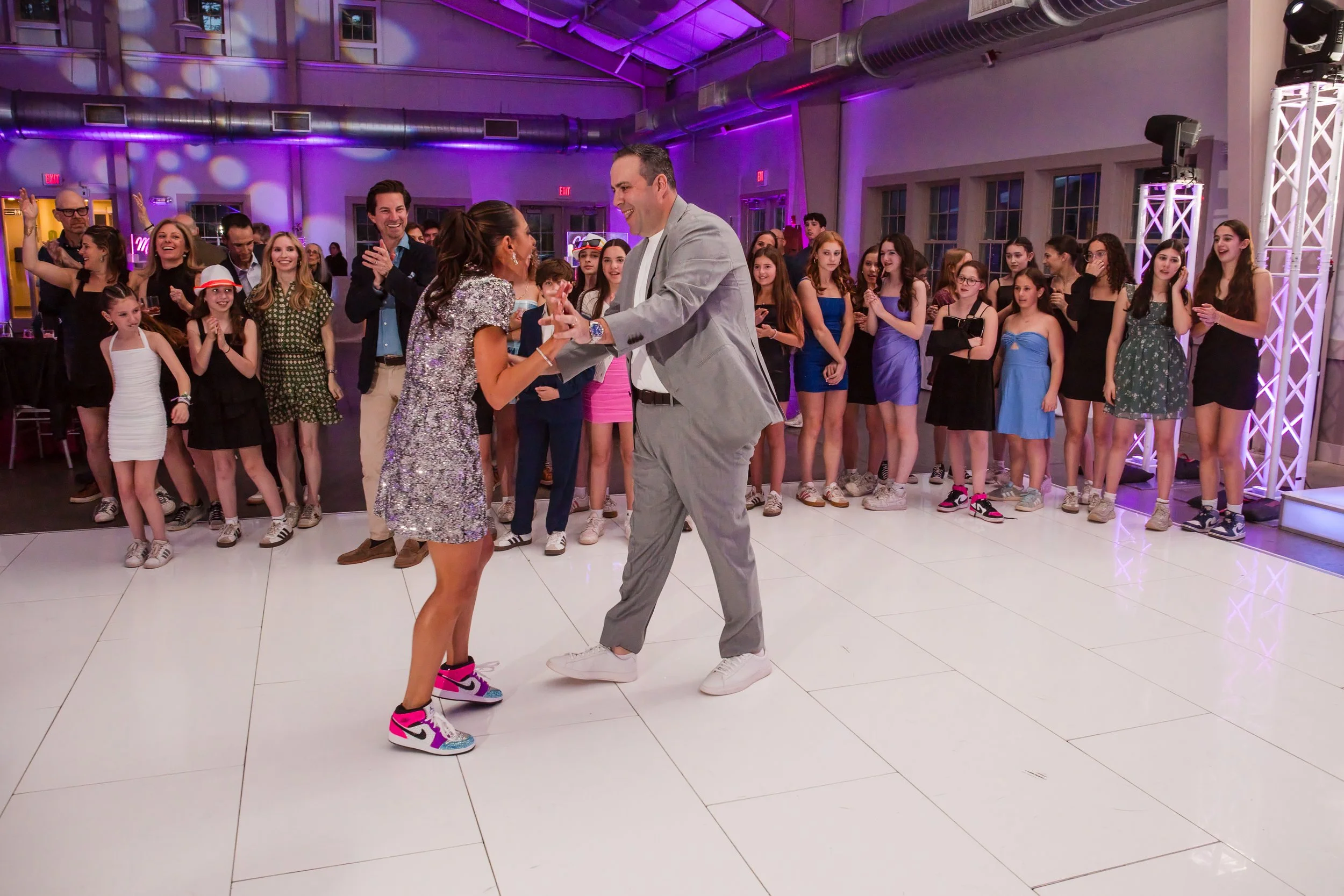 A dance-off on the white dance floor as a crowd of kids watches at the Camp Ramah bat mitzvah