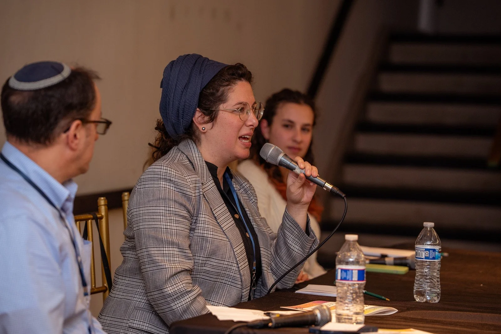 A speaker with a microphone leads a roundtable discussion at the JOFA conference