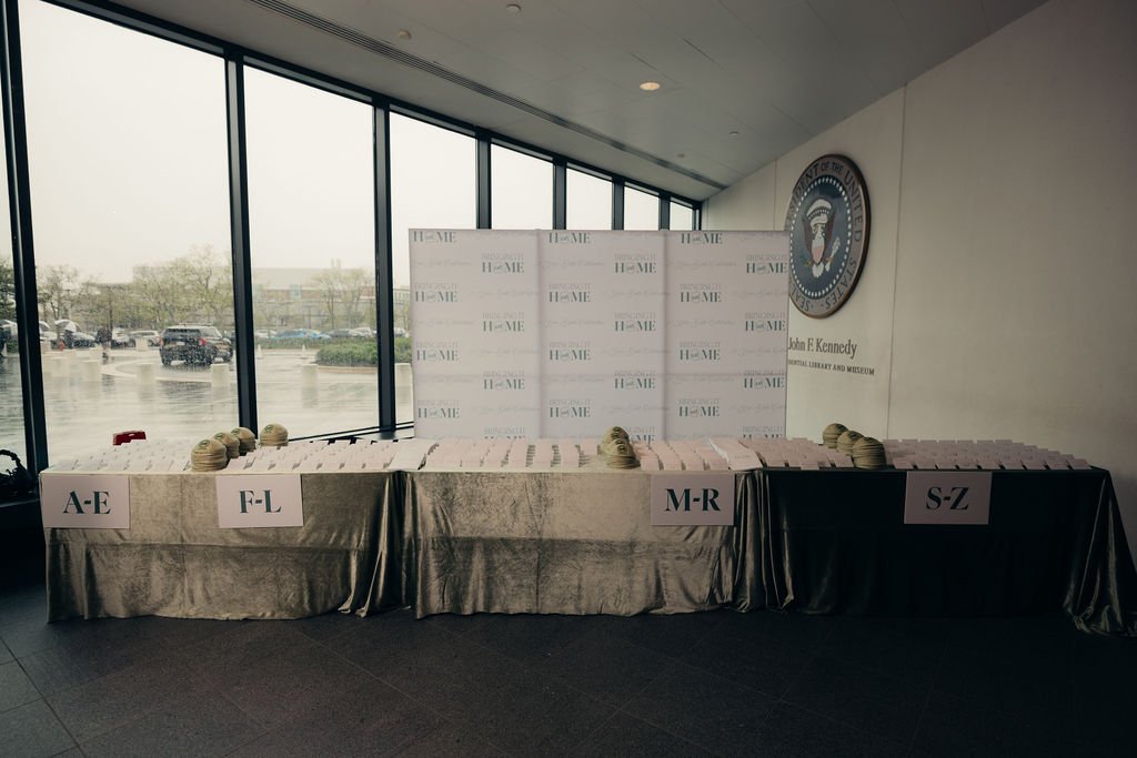 A guest check-in table with alphabetized place cards set up in front of the windows