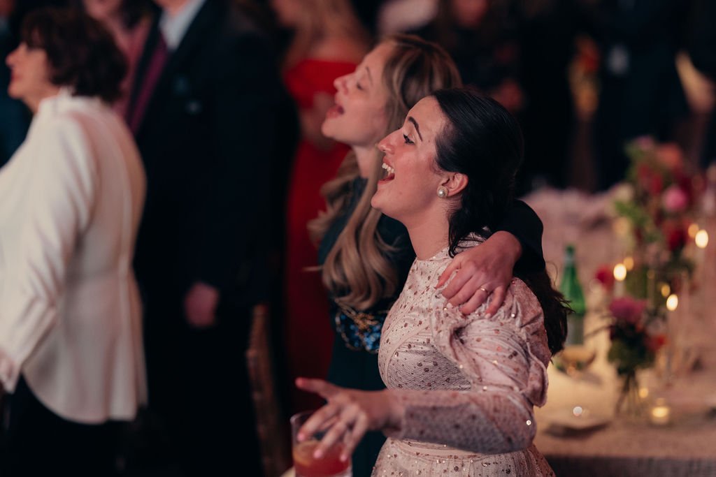 Guests laugh together at a candlelit table during the Chabad Chestnut Hill gala