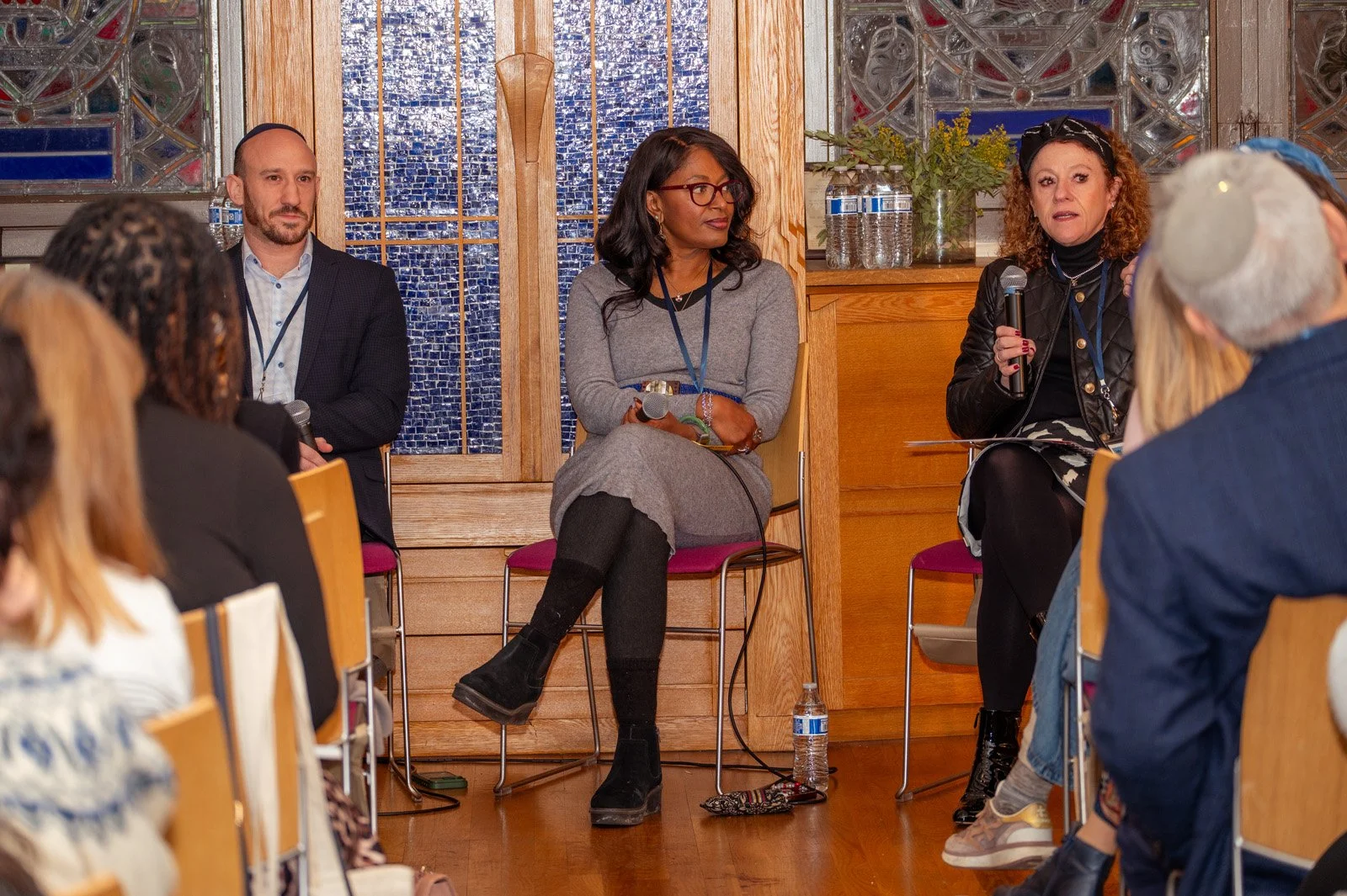 Three panelists lead a breakout session in front of blue tiled walls at the JOFA conference