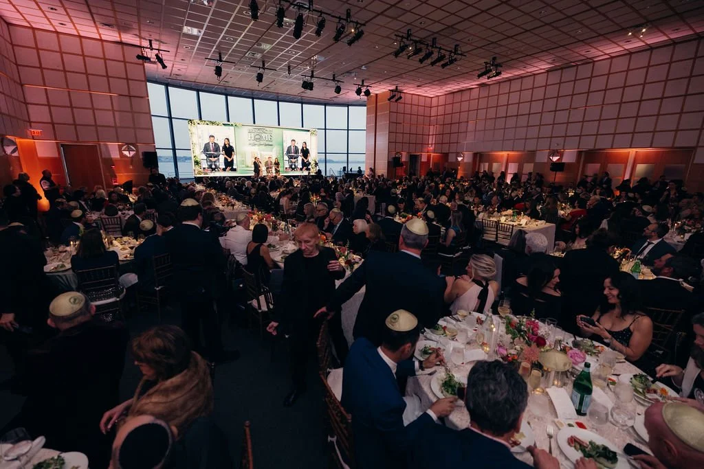 A full ballroom of round tables seen from the back during the Chabad Chestnut Hill gala program