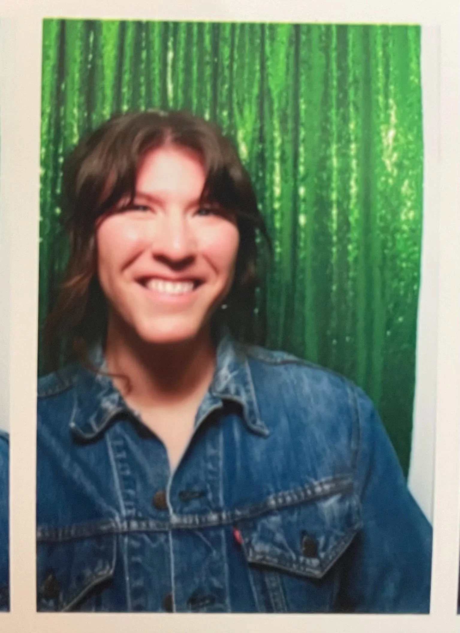 Laura is pictured smiling in a photo booth.
