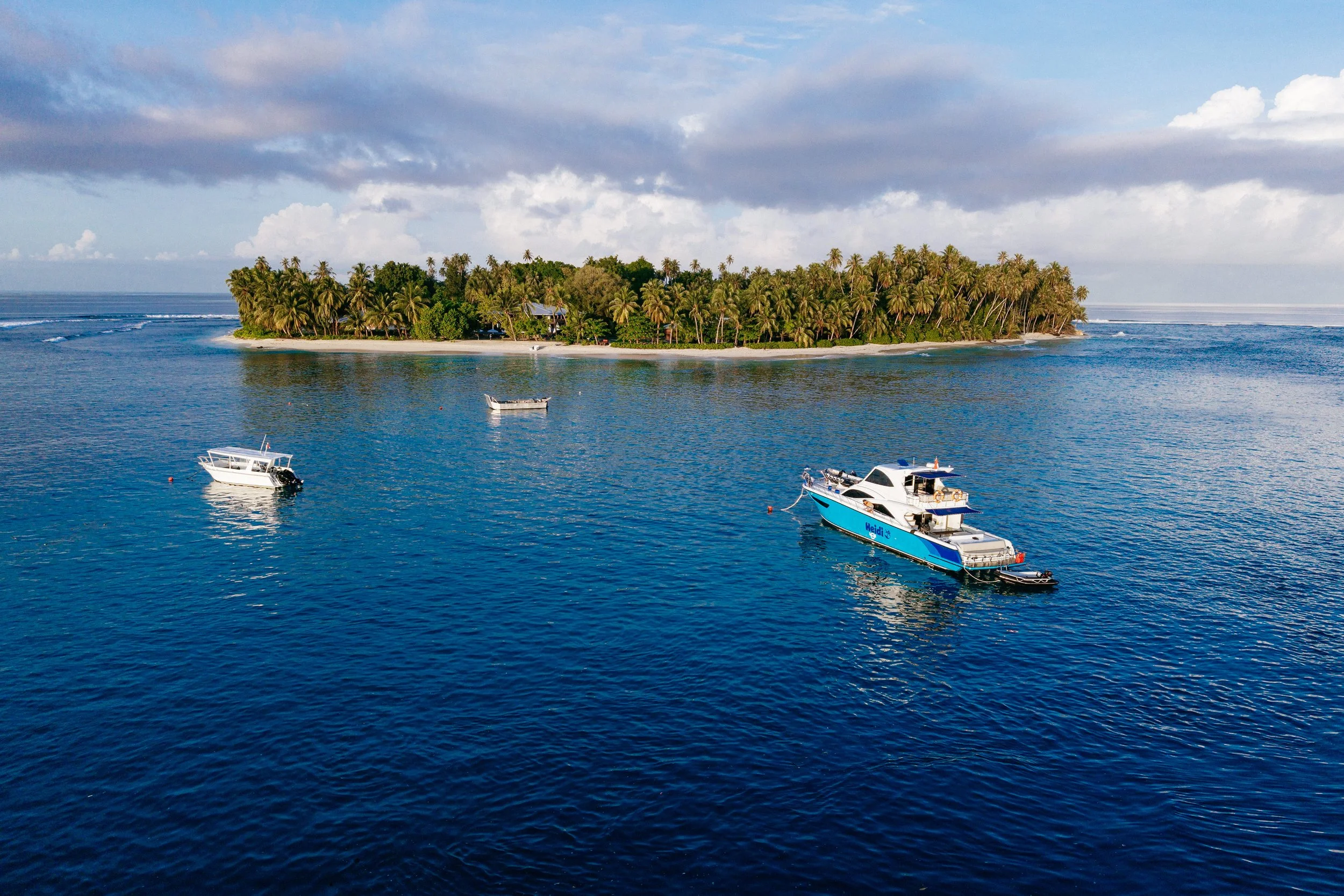 The fleet and island in an aerial view during a glowing sunrise.