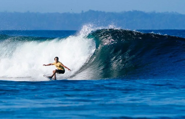 Surfer riding a wave near Tanah Mympi