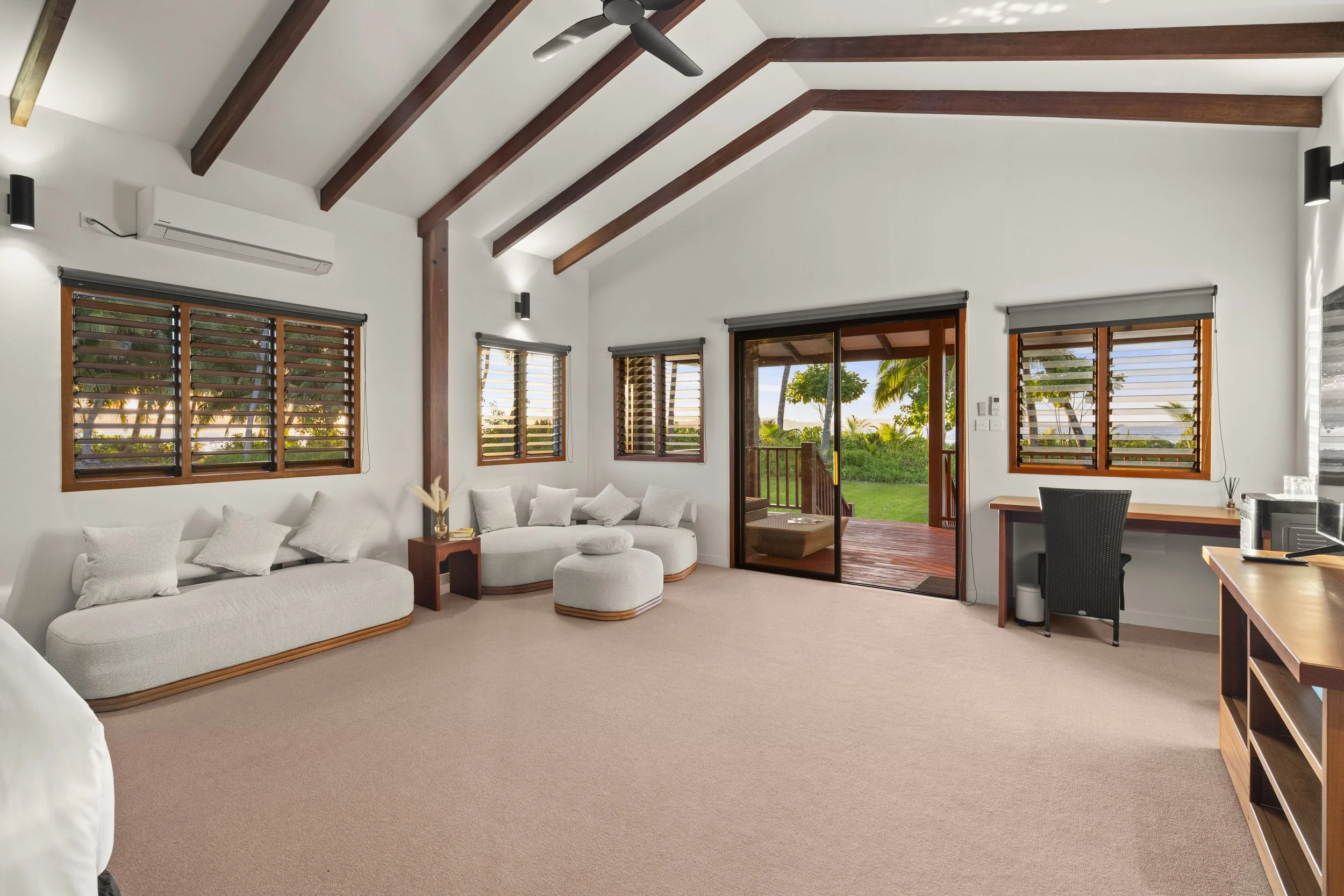 The bedroom in an Ocean View suite at Tanah Mympi, with windows looking out to the water.