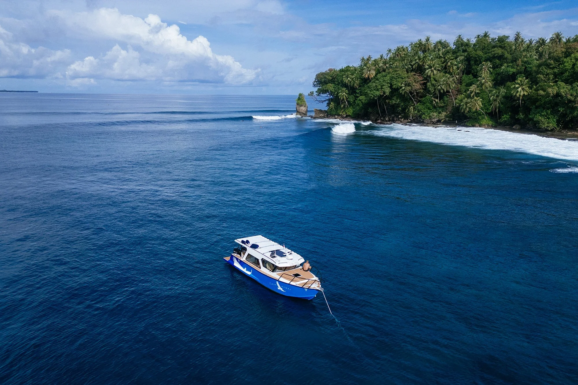An aerial view of several reef breaks near Tanah Mympi, boats positioned in the lineup.