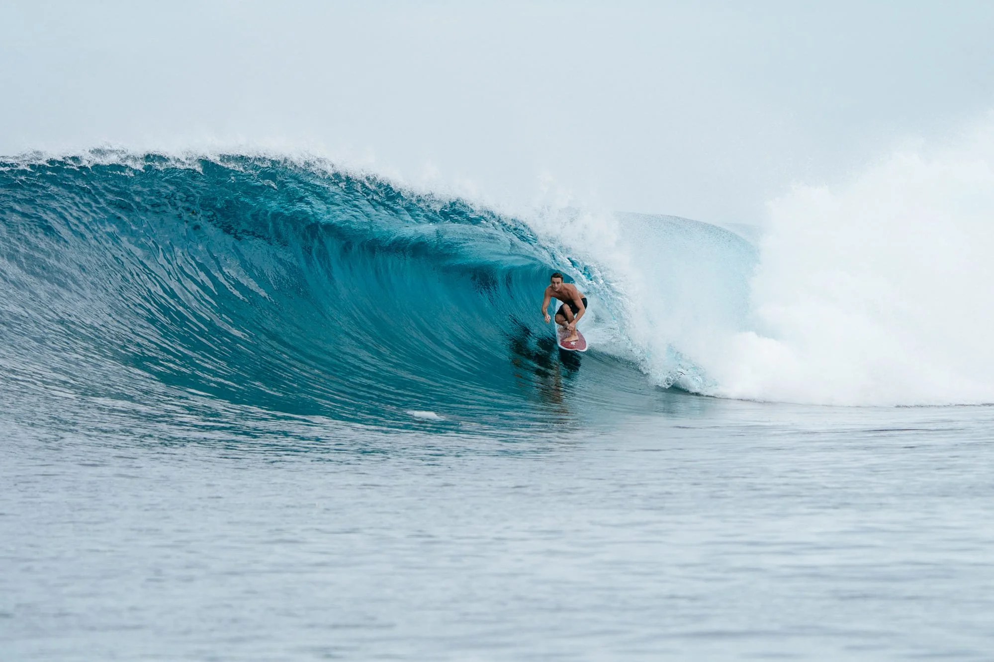 A surfer rides deep inside a barreling wave near Tanah Mympi.