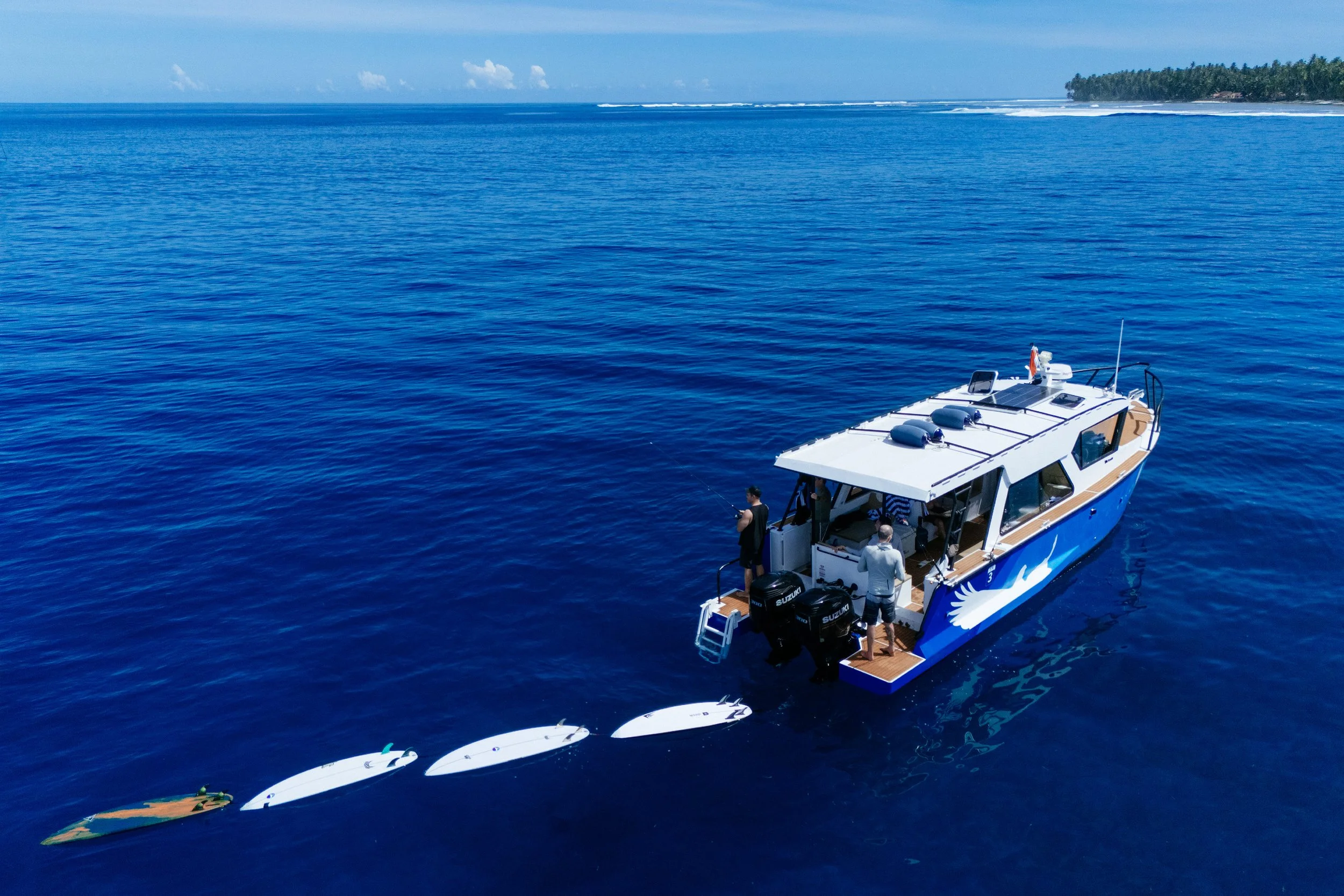 An aerial view of a Tanah Mympi boat in the clear water surrounding the islands.