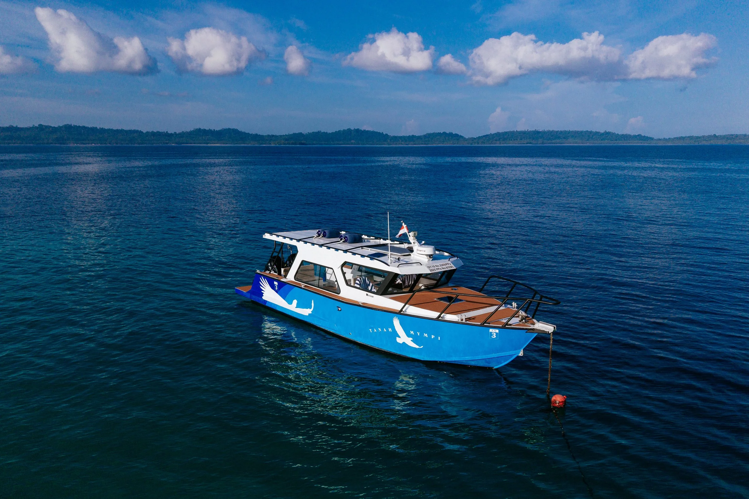 TM3, Tanah Mympi's 38-foot transfer boat, cutting through the water near the islands.