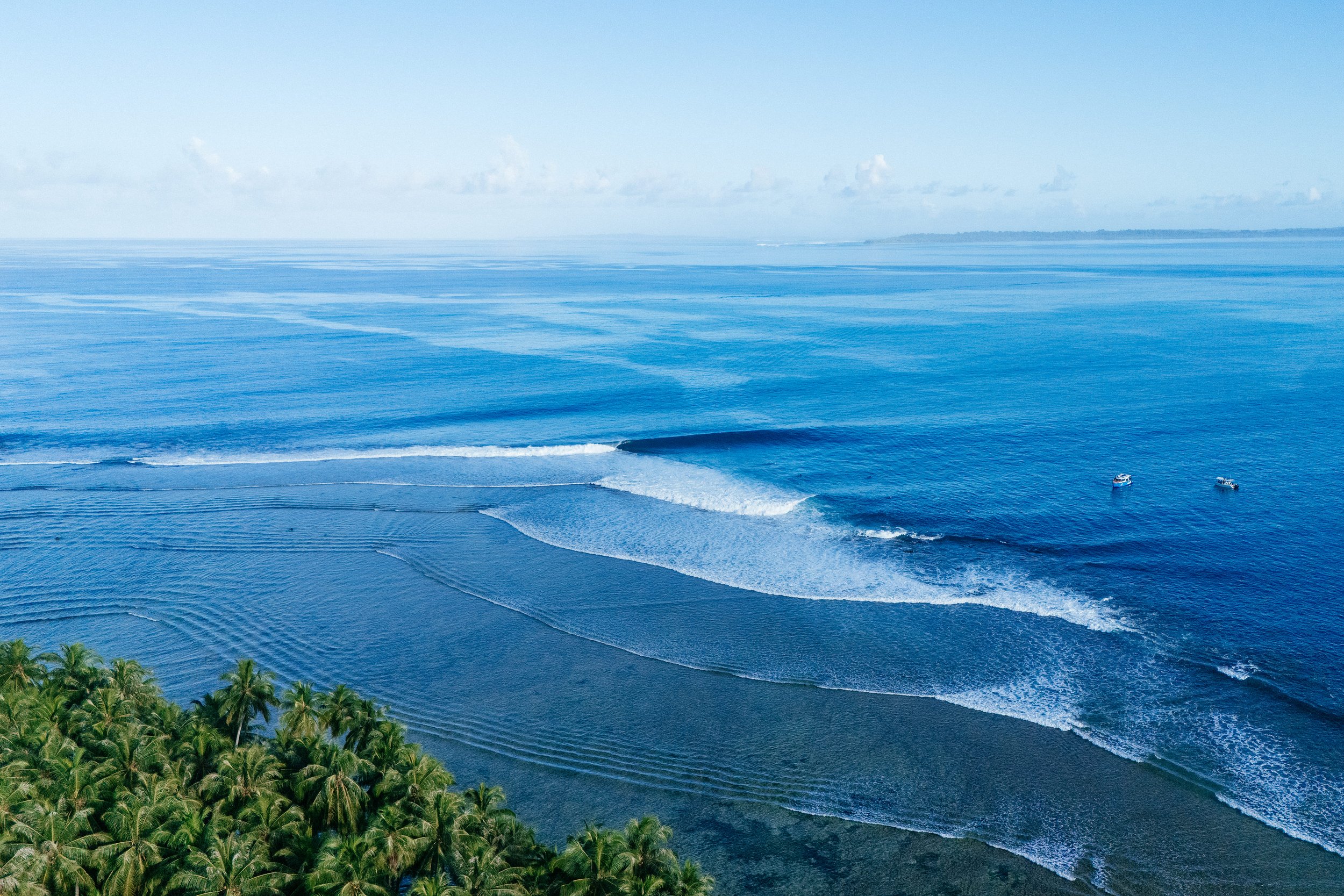 A surfer launches an aerial maneuver on a wave near Tanah Mympi.