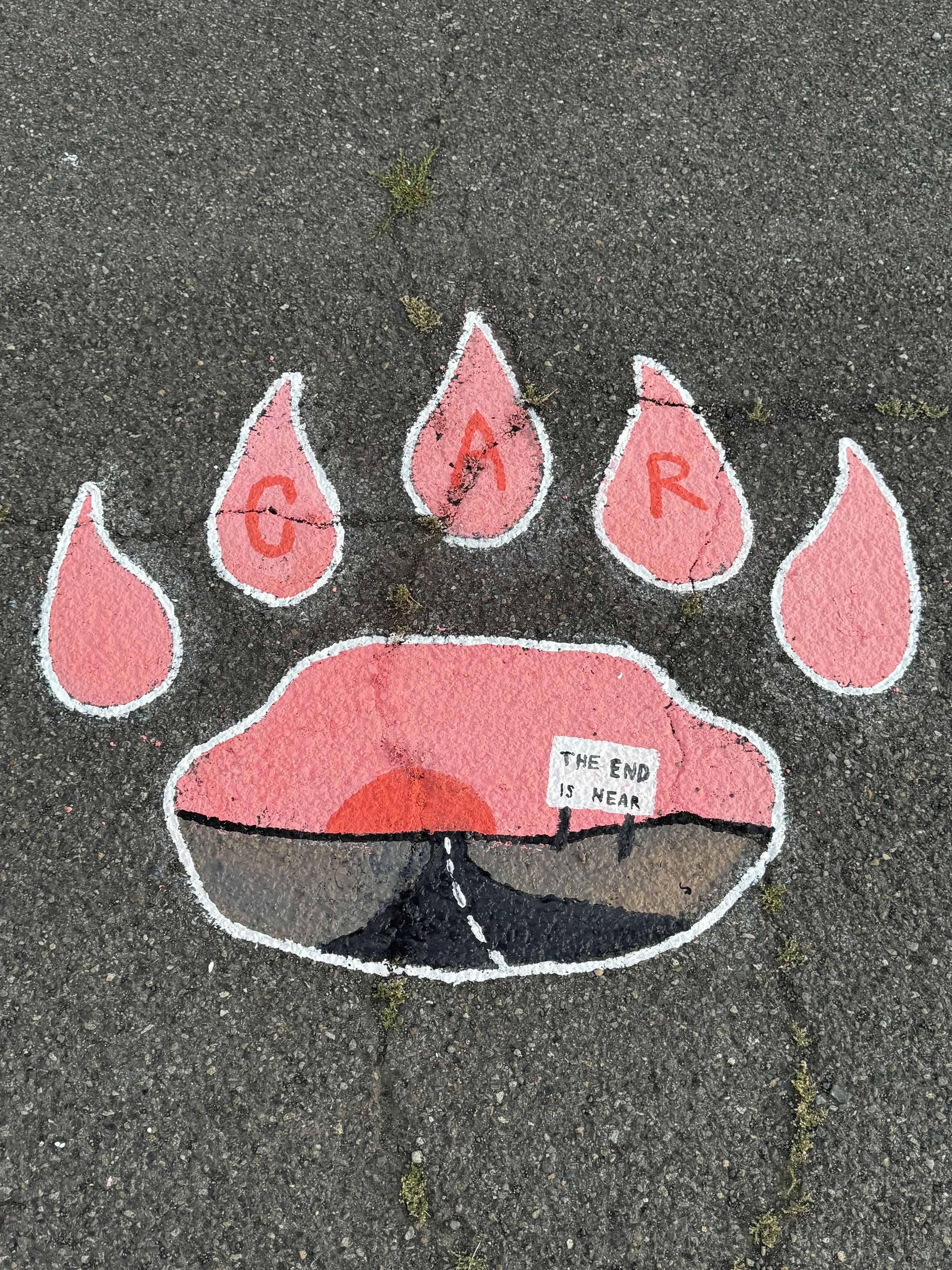 Colorful chalk drawing of a bear paw on the pavement with four teardrop-shaped marks labeled G, A, R, and C, and a sign that reads 'The end is near'.