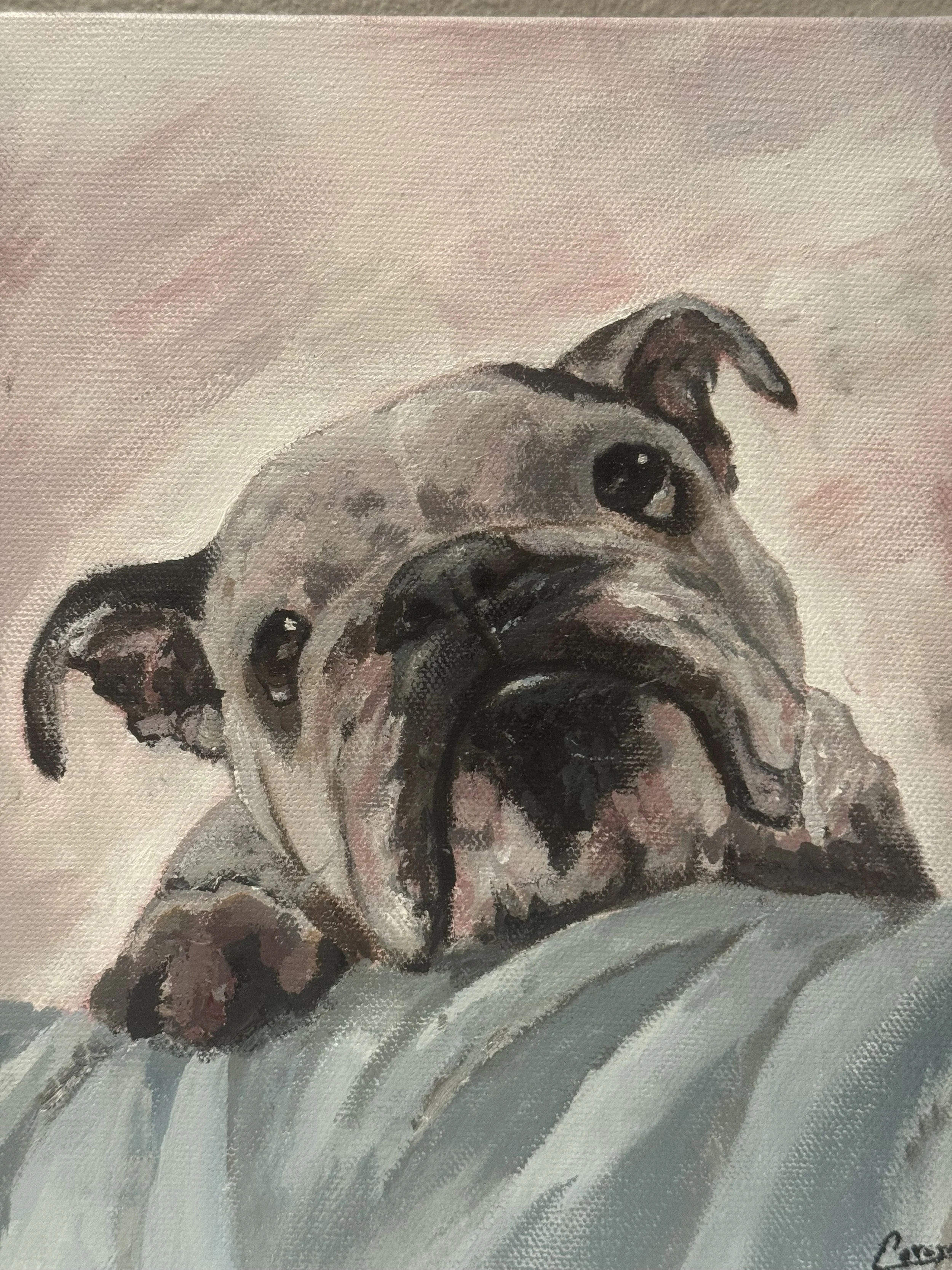 Close-up of a painted pug dog with expressive eyes, pink tongue slightly out, and a beige background.