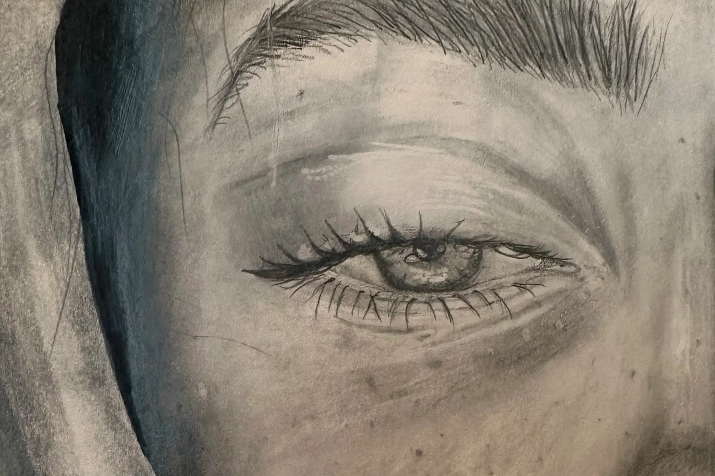Sketch of a closed eye with detailed eyelashes, eyebrows, and shading around eye area.
