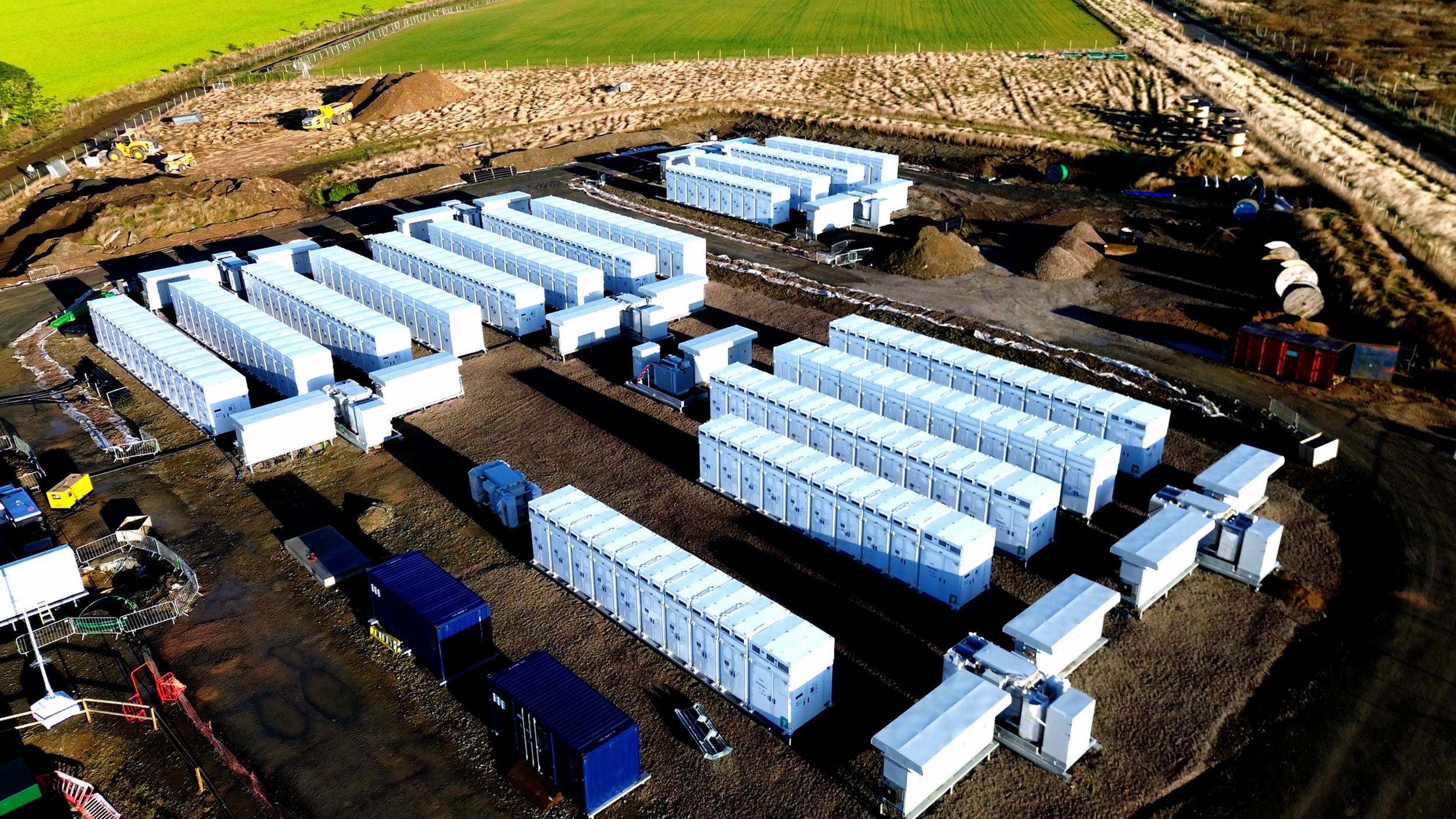Several white battery storage units positioned across an active Ener-G Services site.