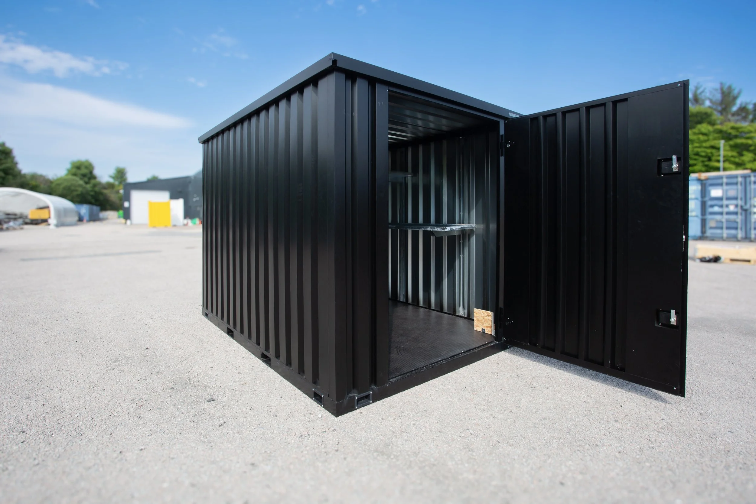 Site Store modular container standing open in an outdoor yard, with part of the interior visible.