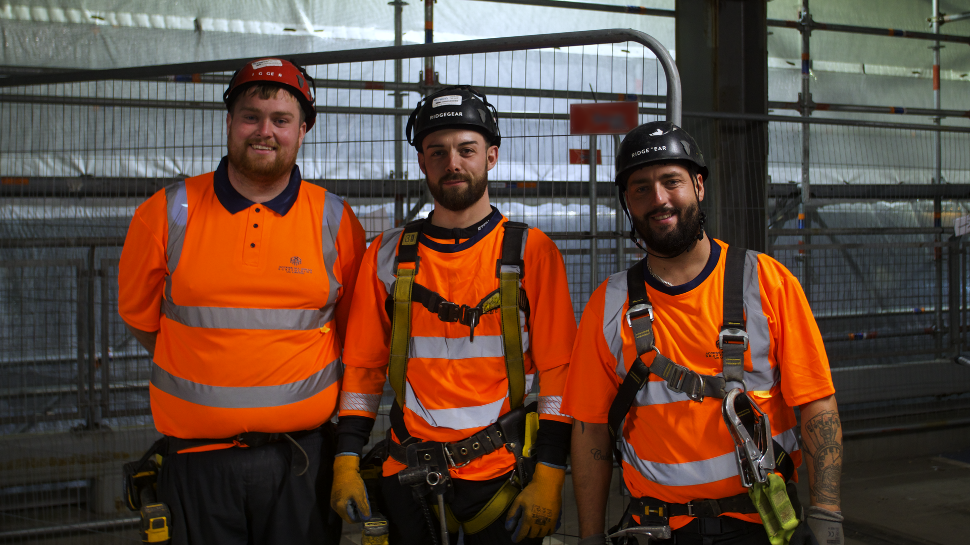 Three AAA Scaffolding team members posing for a photograph on site.