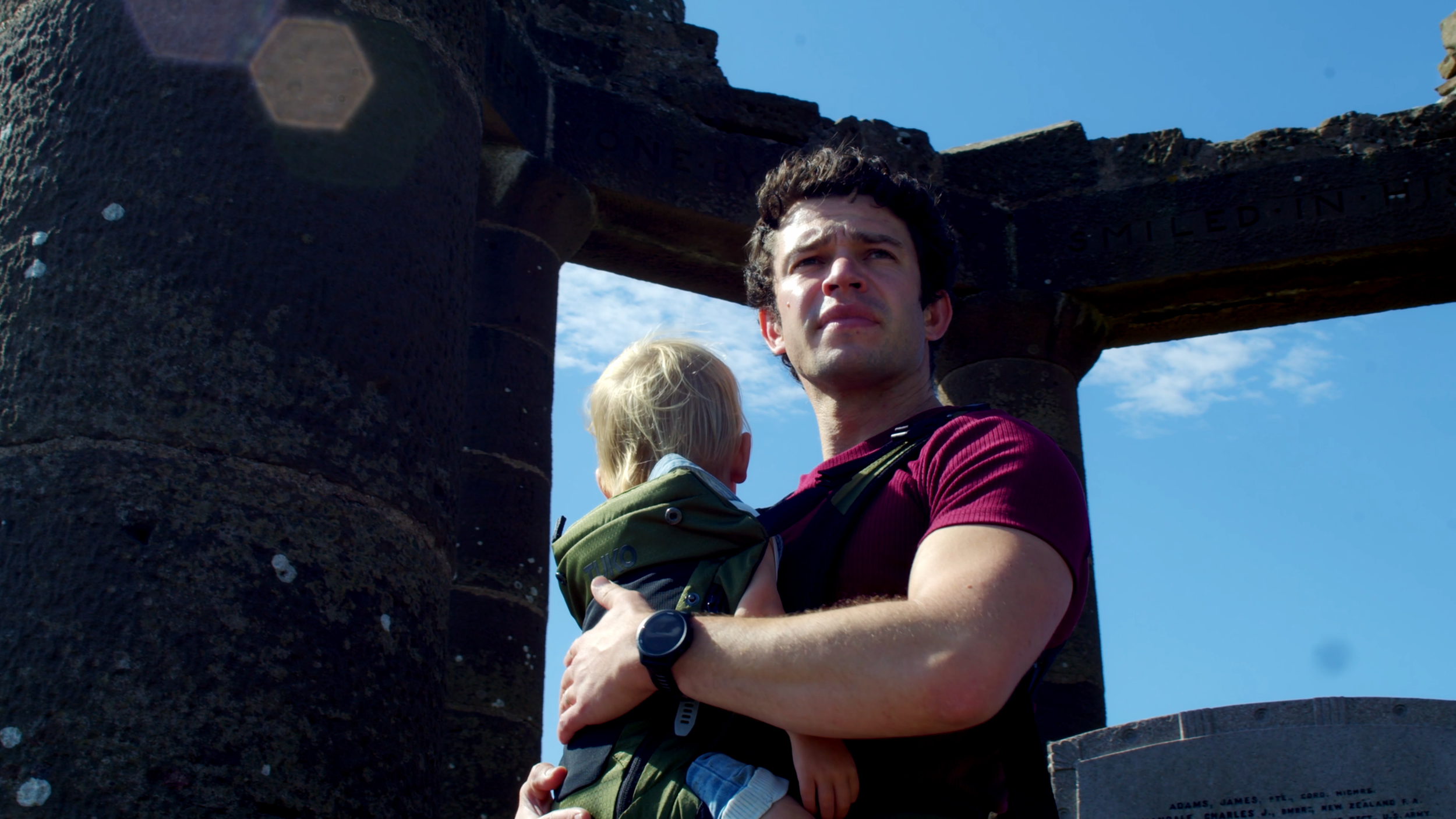 TUKO owner and his son looking into the distance with a monument behind them.