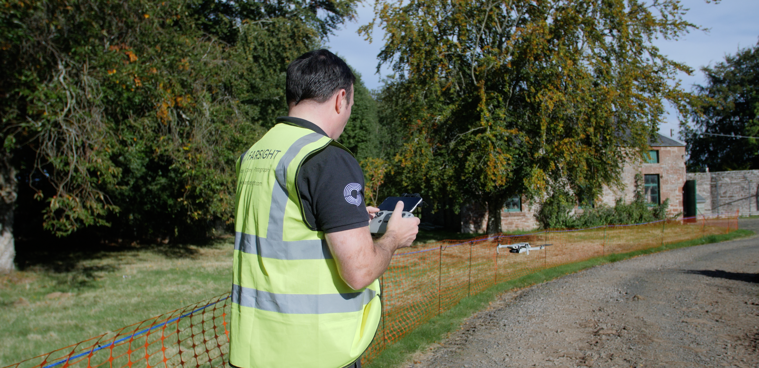 Michael Silva of Farsight operating a drone on the AAA Scaffolding site while wearing a high-visibility vest.