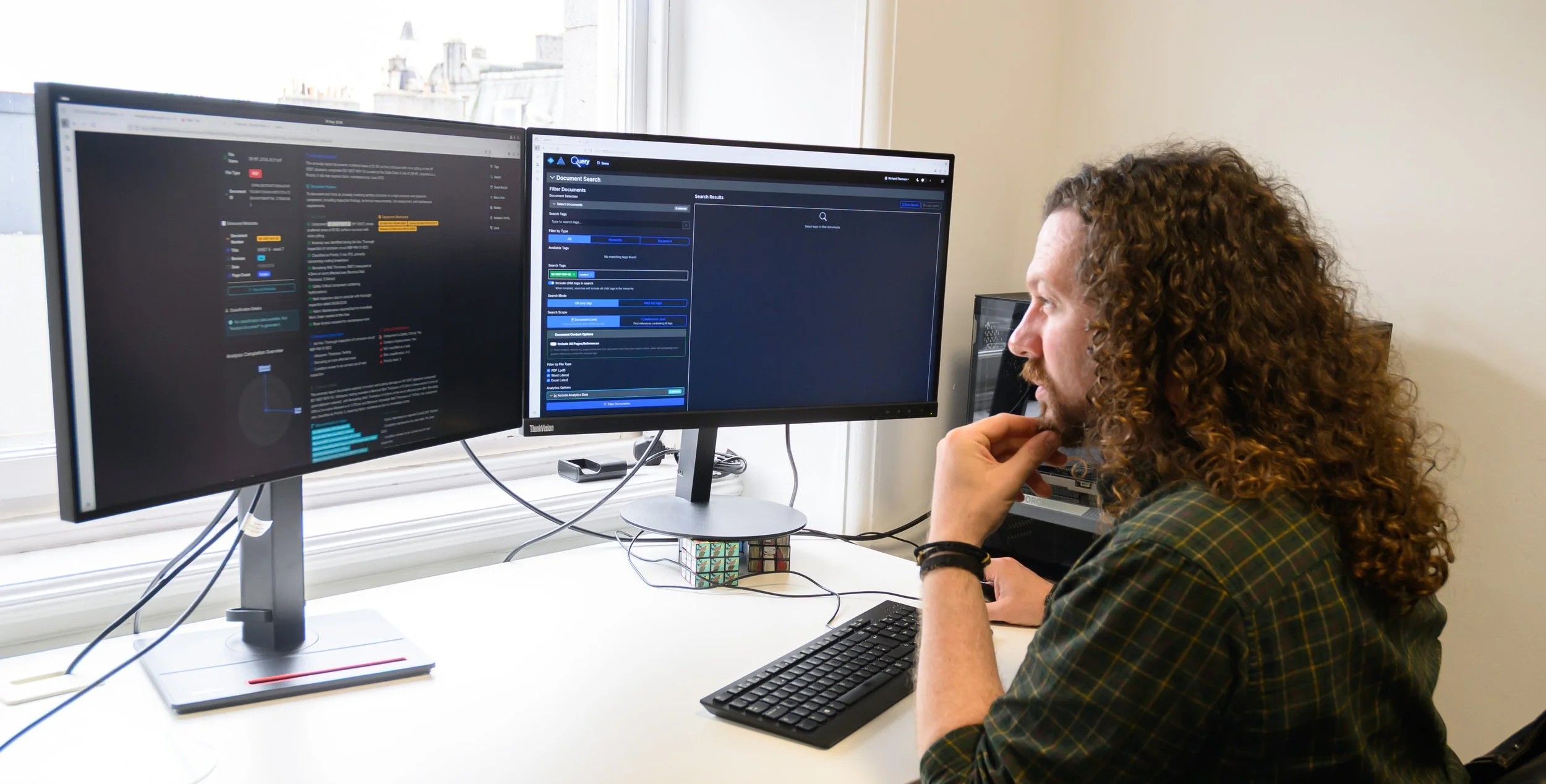 IMRANDD team member working at a desk with data displayed across two monitors.