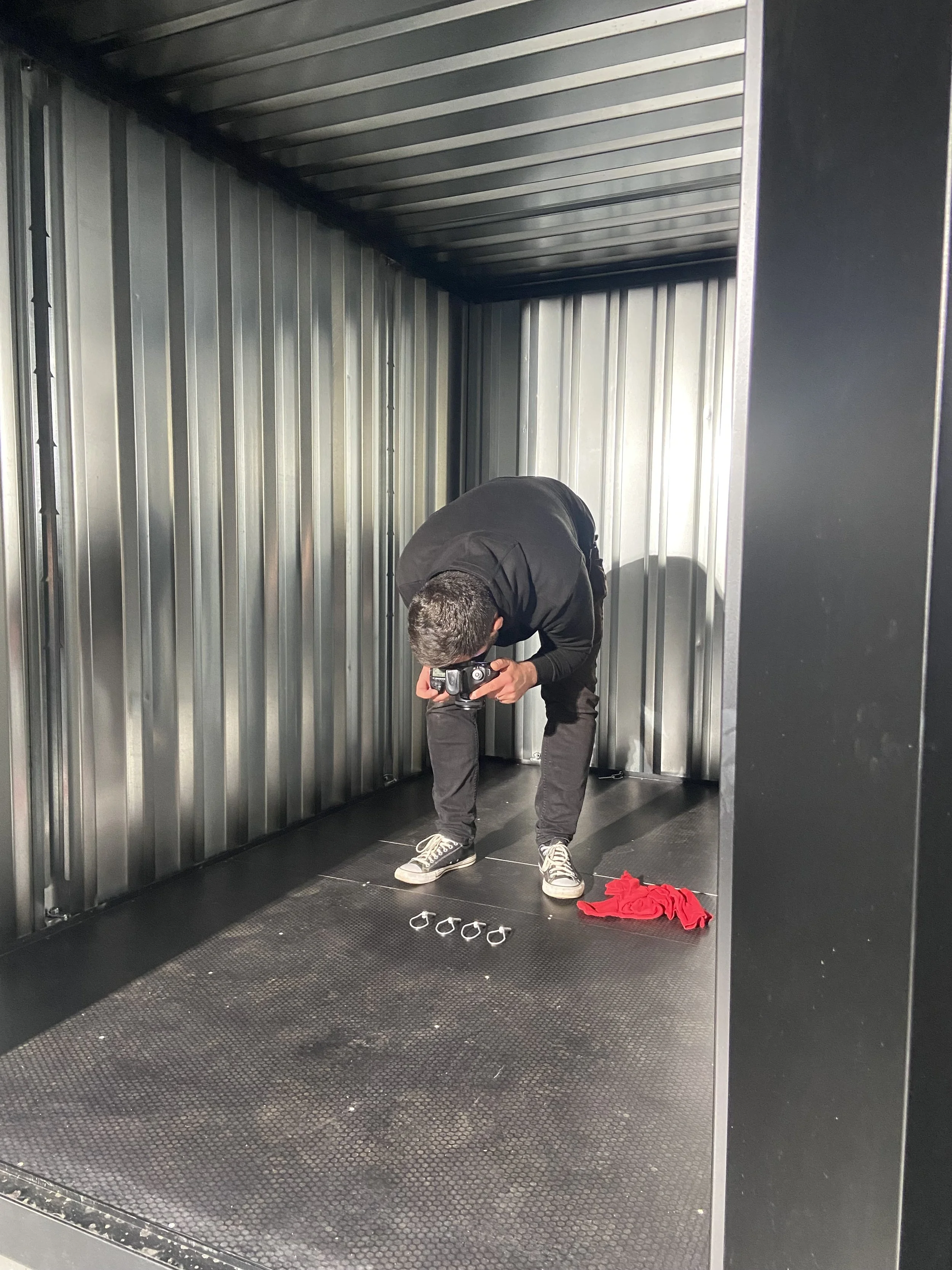 Farsight team member photographing tools arranged inside the Site Store container.