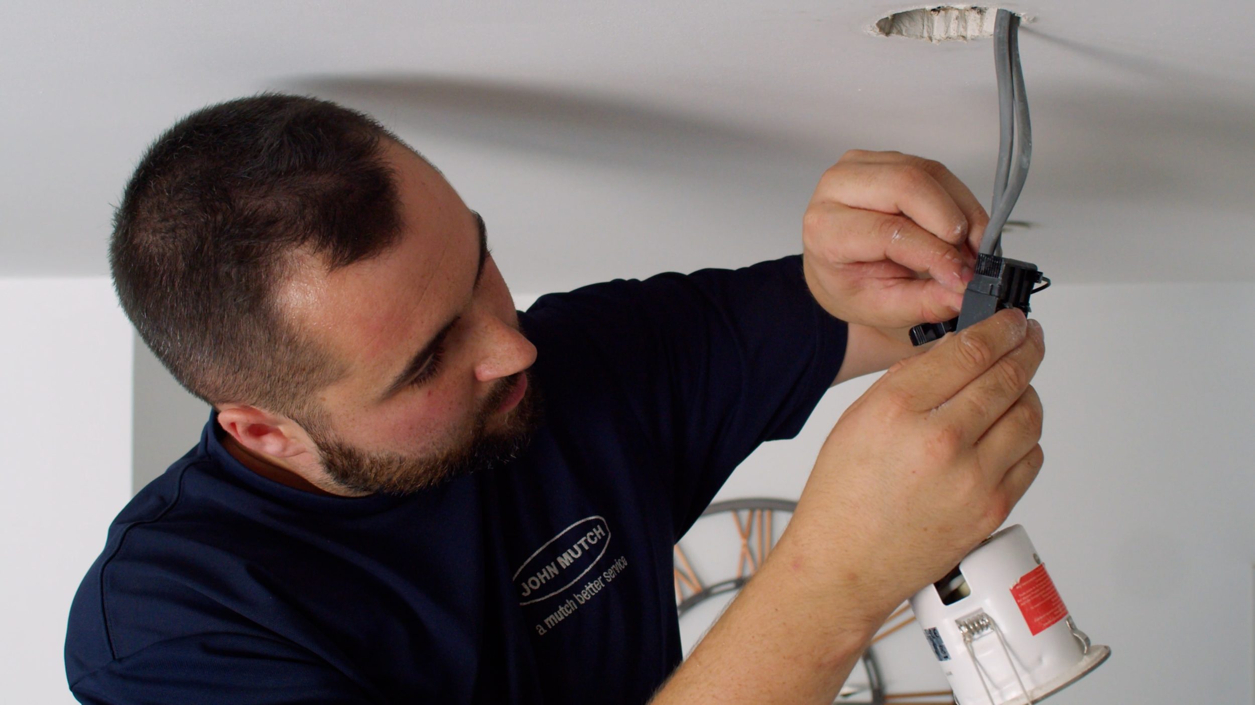 John Mutch Building Services electrician wiring a light.