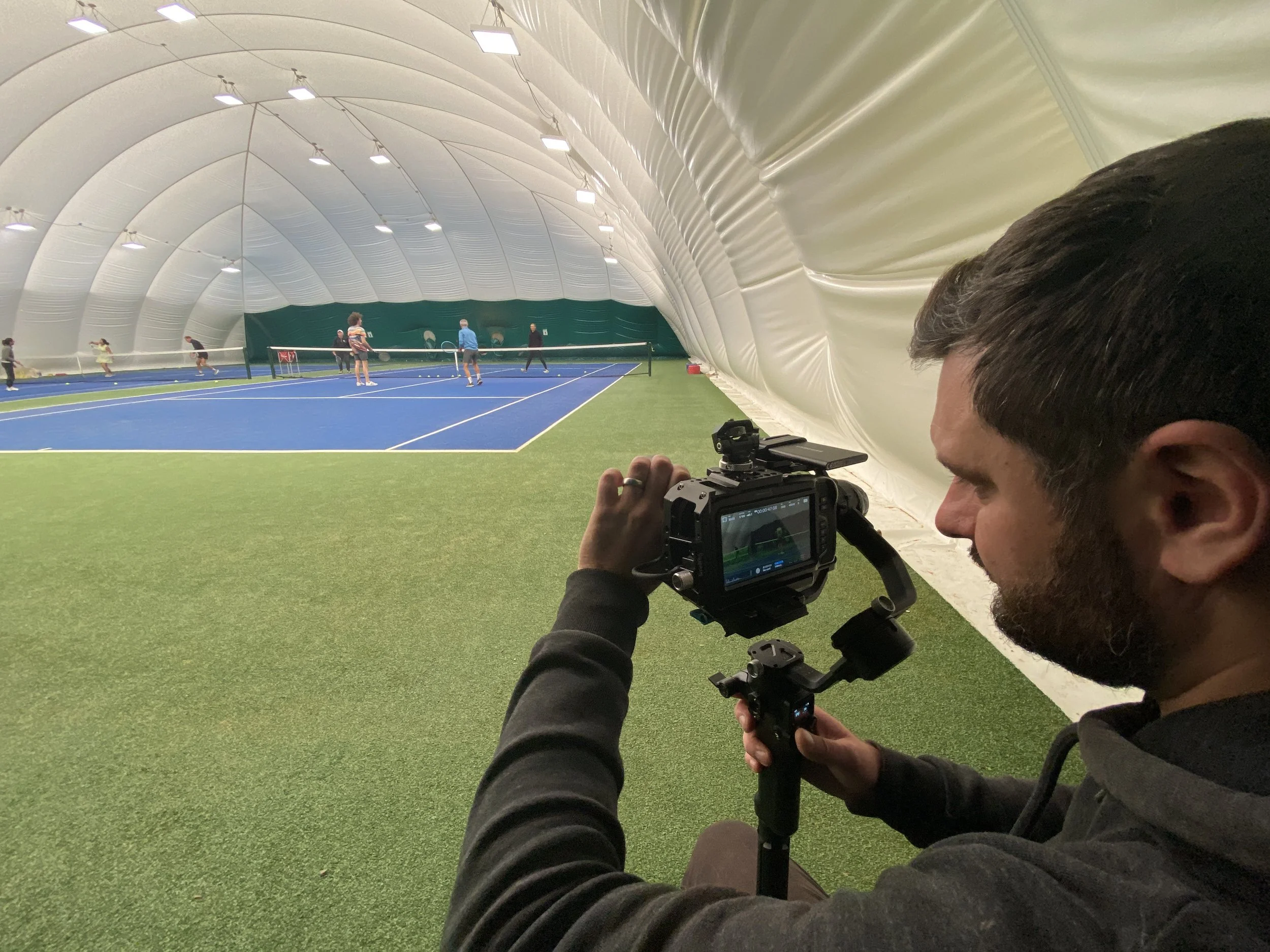 Farsight crew member filming a tennis session at Kippie Lodge.