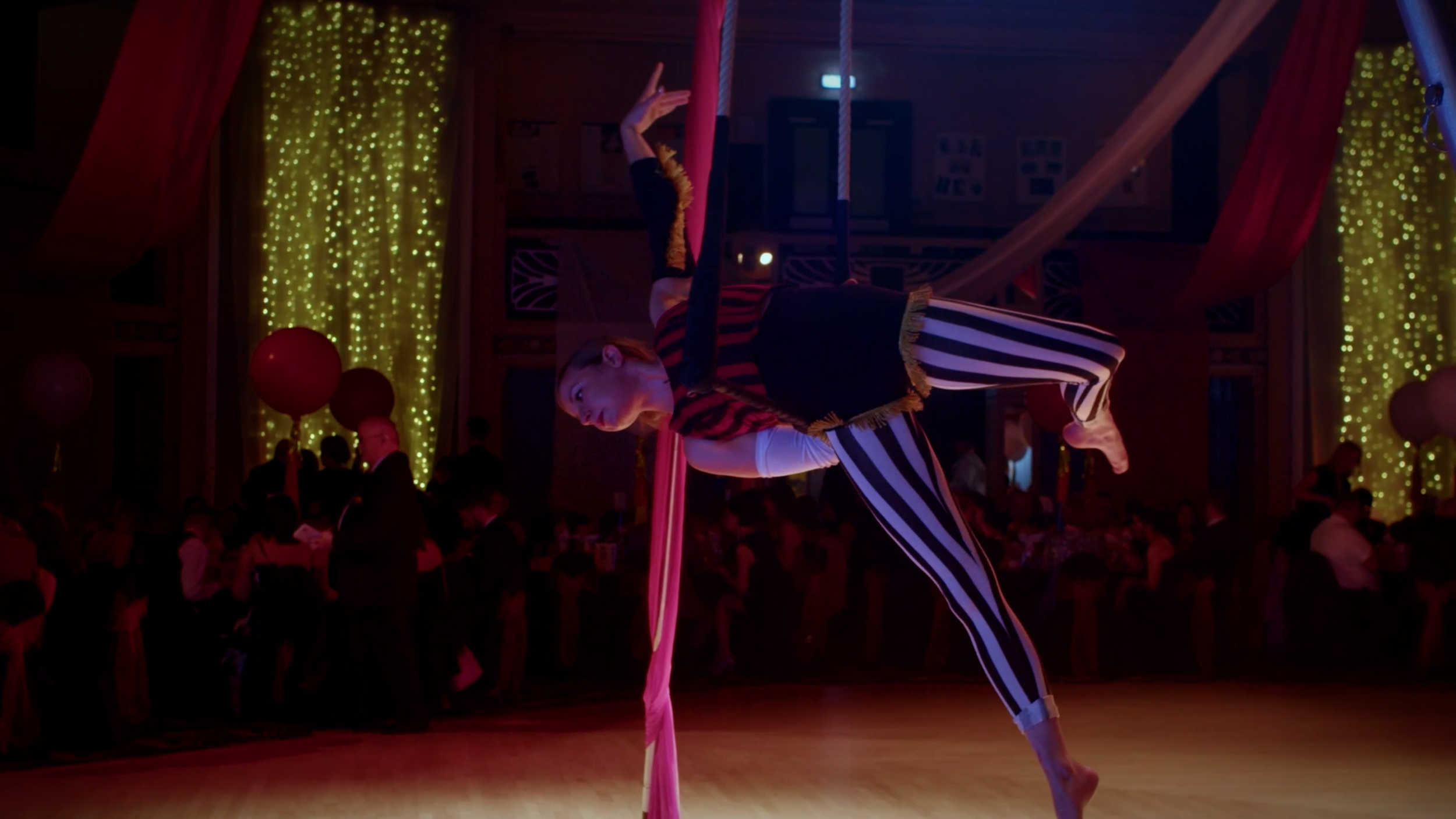 Circus performer using aerial silks on stage at the CLAN Cancer Support annual ball.