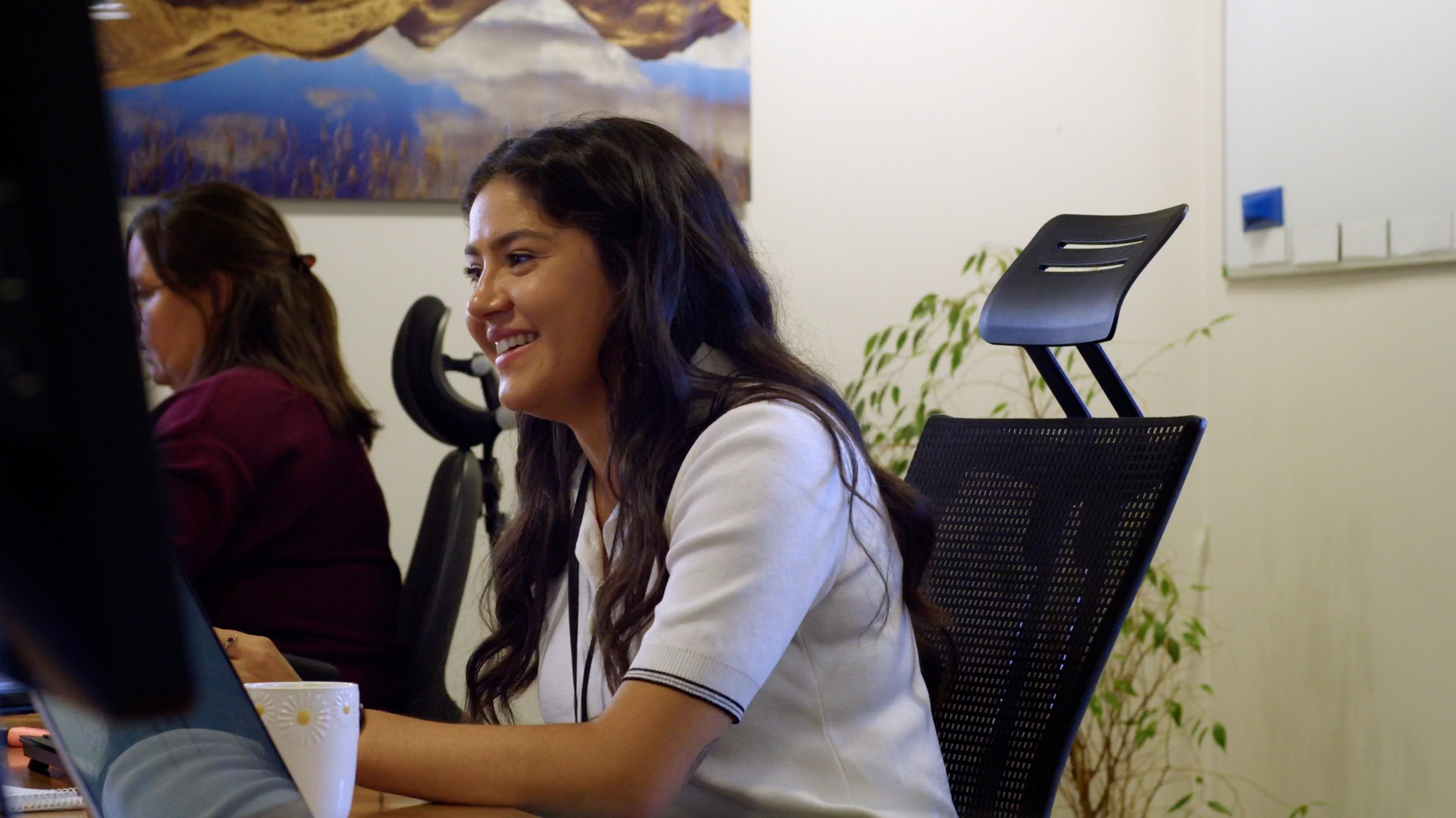 Arnlea Systems team member smiling while seated at their desk.