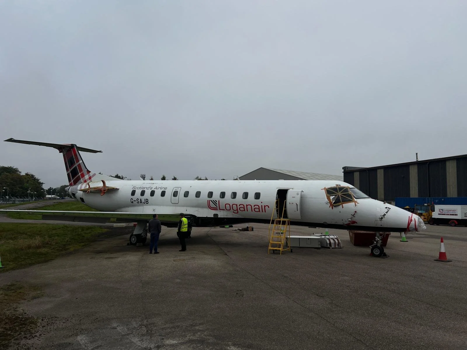 Wide view of the aircraft with two people speaking beside it during the decommissioning project.
