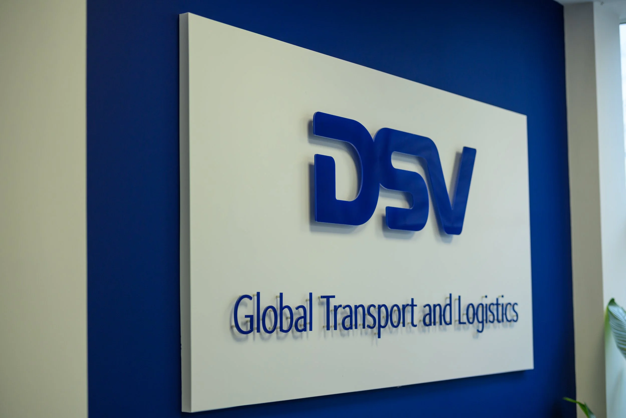 Blue DSV logo displayed on a white wall at the Aberdeen facility.