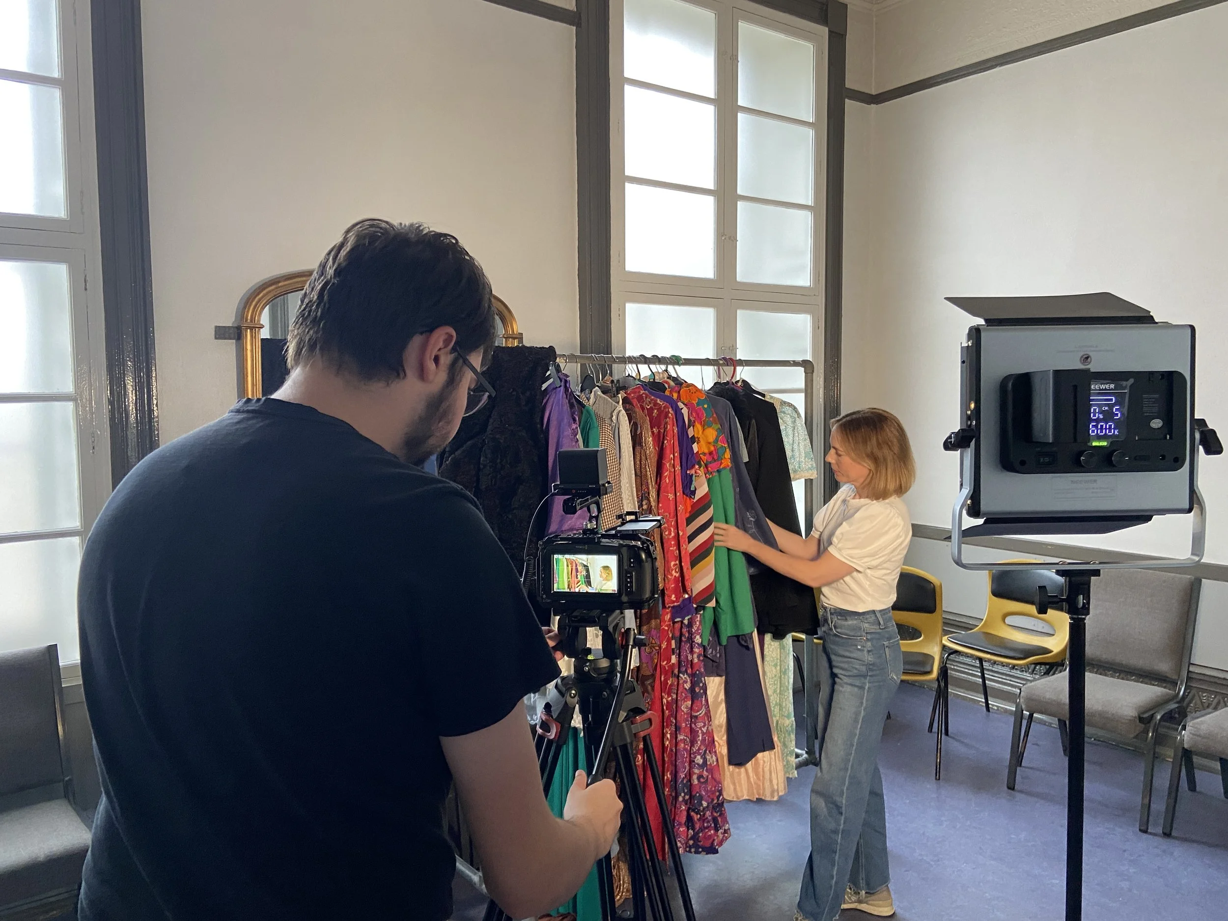 Farsight crew member filming Laura Main looking through costumes backstage at Aberdeen Arts Centre.