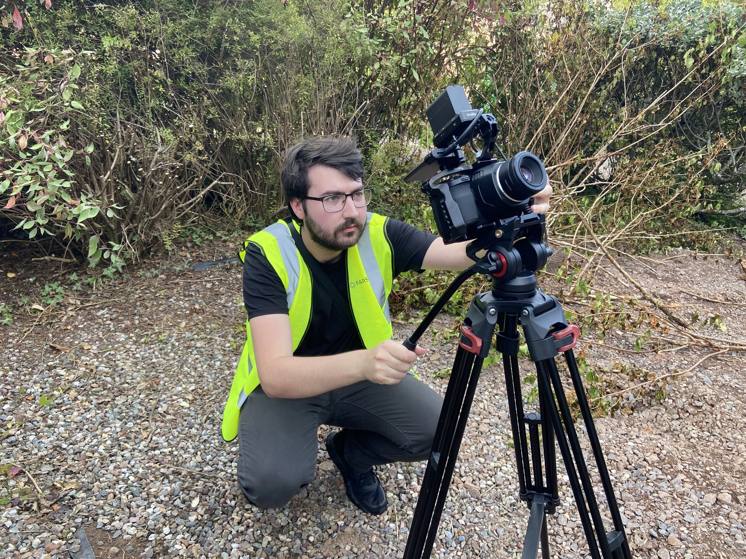Farsight crew member filming on the AAA Scaffolding site while wearing a high-visibility vest.