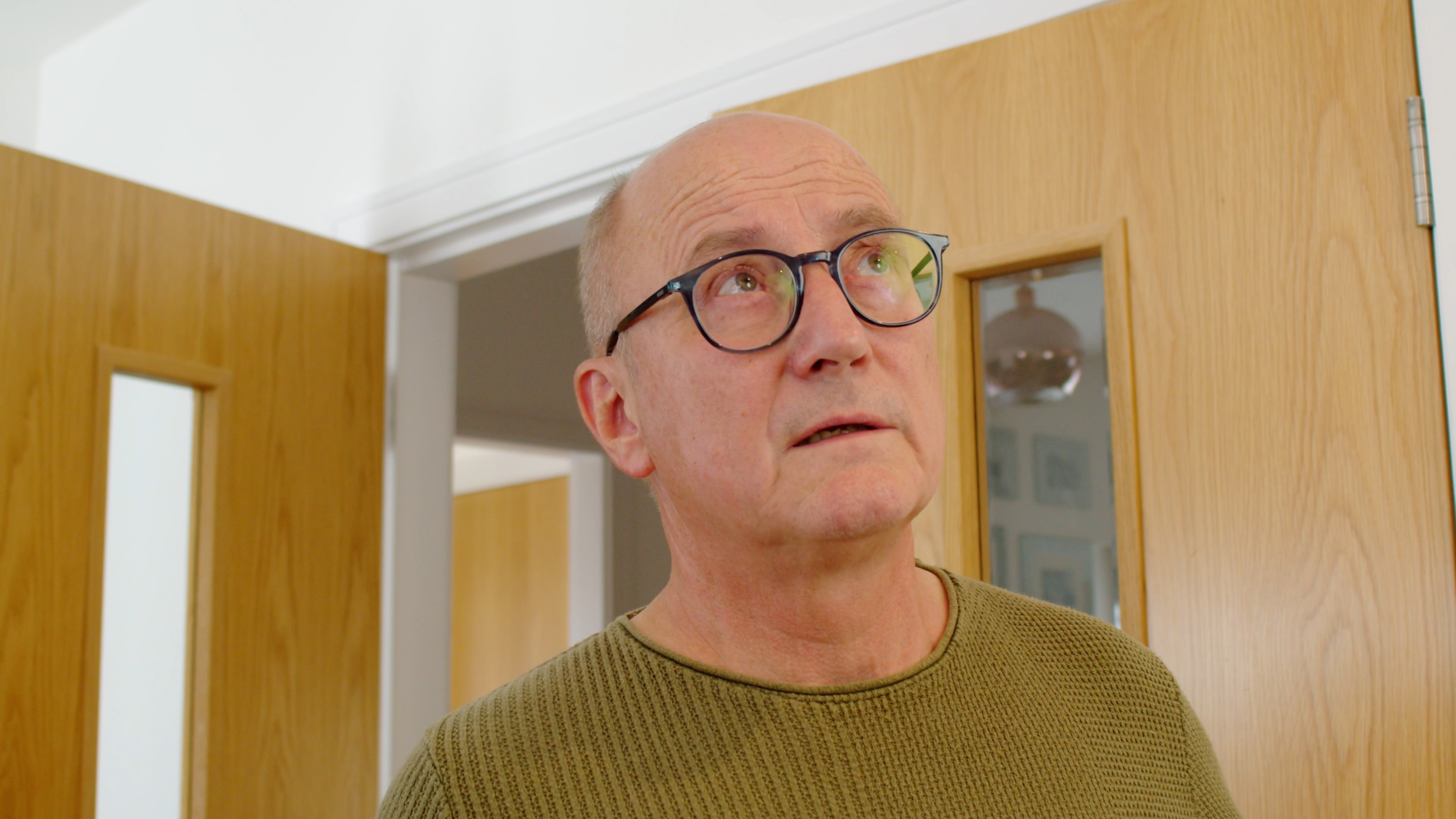 Man looking perplexed in a kitchen during the John Mutch Building Services brand film.