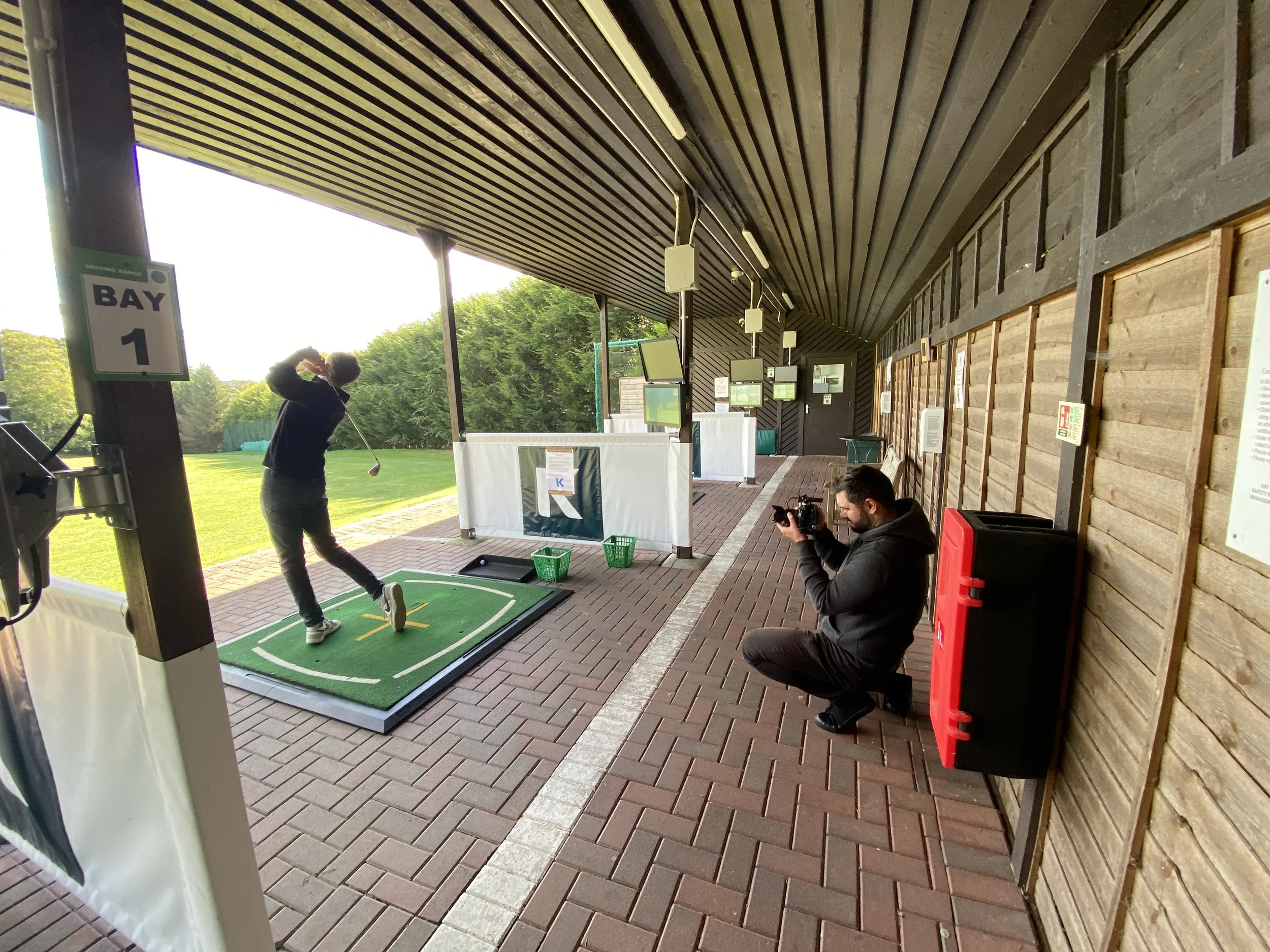 Farsight crew member filming a golfer practising at the Kippie Lodge golf range.