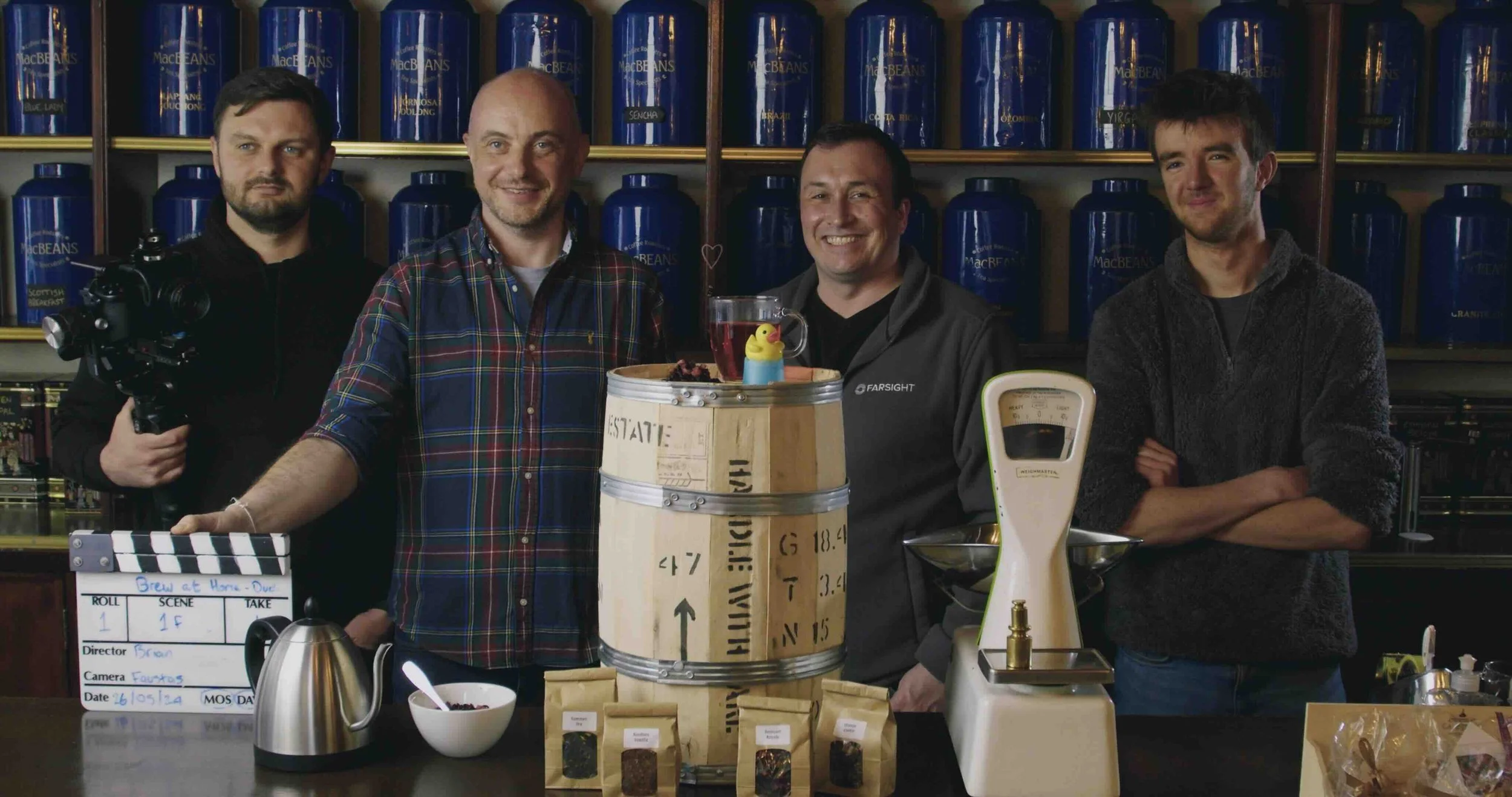 MacBeans owner Brian with Michael Silva and two Farsight crew members beside a barrel and a table containing tea, a kettle and a film slate.
