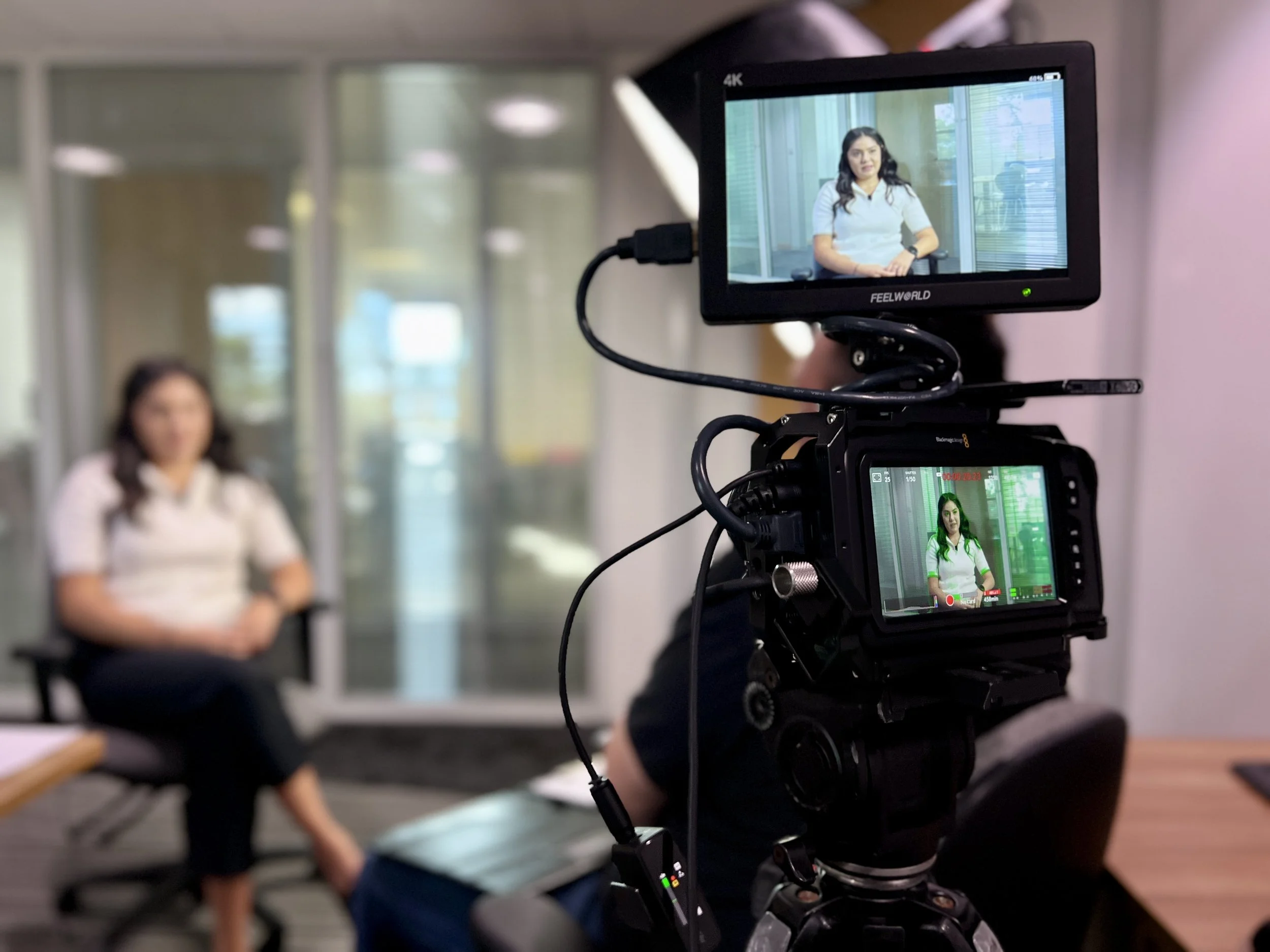 Arnlea Systems team member being interviewed with a video camera visible in the foreground.