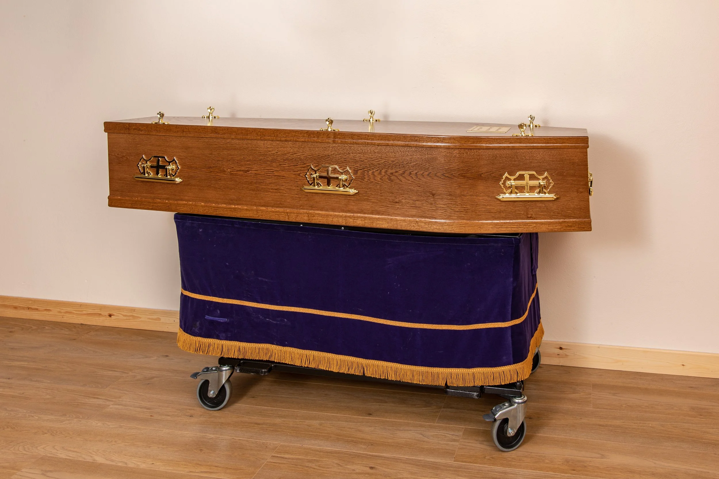 Flat lid coffin light oak veneer. Also available in dark oak veneer. Full details: flat lid, plain sides, all plastic fittings as required by crematorium. Satin interior and engraved nameplate.
