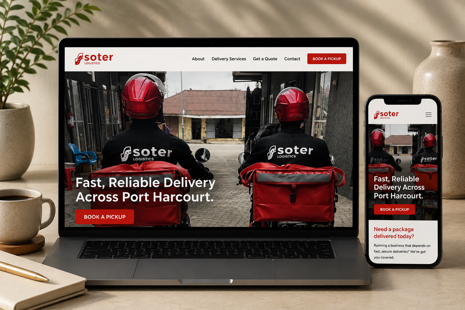 A laptop and a smartphone display the same webpage for Soter Logistics. The webpage features two delivery workers wearing red helmets and black jackets with the company's logo, seated with their backs facing the camera. The text on the screen reads 'Fast, Reliable Delivery Across Port Harcourt,' with a red button labeled 'Book a Pickup.' The background shows a building with a brown roof and some outdoor chairs.