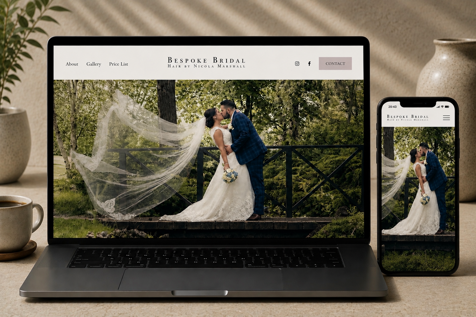 Laptop and phone displaying a wedding photo of a bride and groom kissing outdoors amidst greenery.