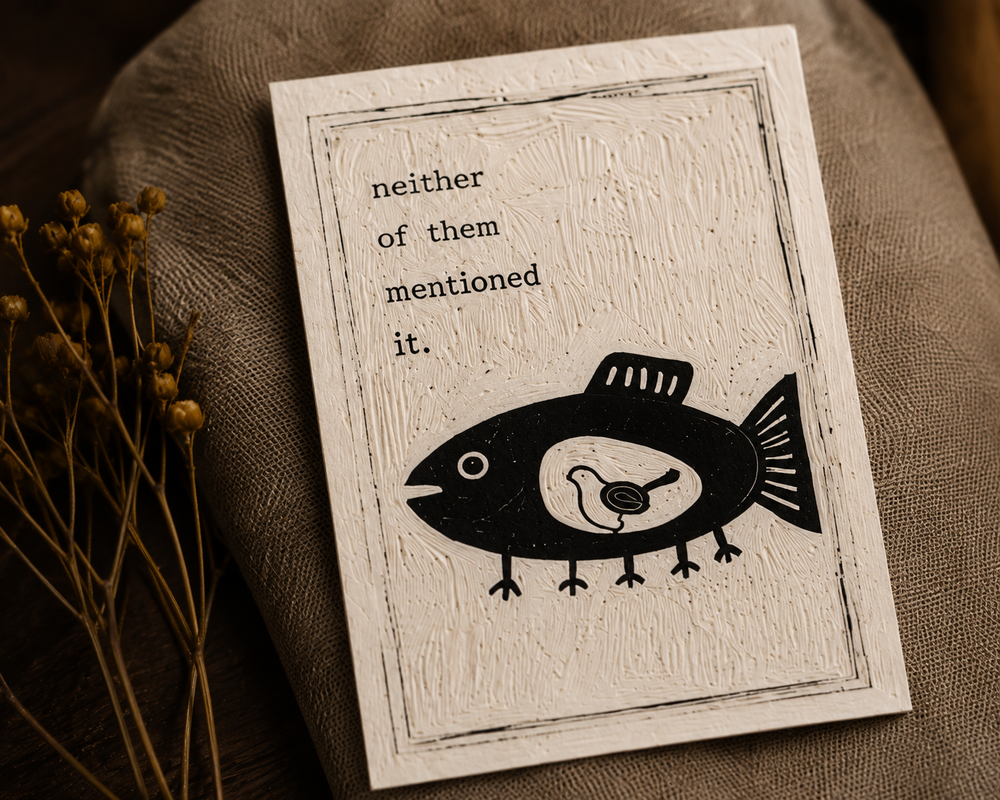 A textured beige card with a black illustration of a fish with a duck inside it and the text "neither of them mentioned it."