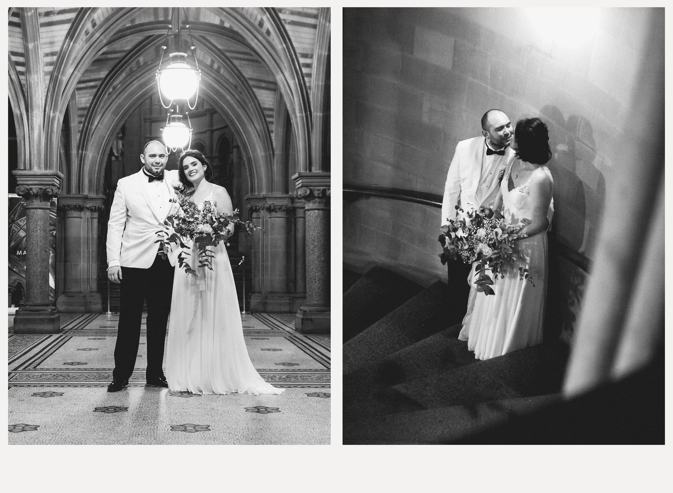 A black and white photo of a newlywed couple during their wedding at an ornate, arched hall. The groom is wearing a white tuxedo jacket with a black bow tie, and the bride is in a long, white wedding gown holding a large bouquet. They are smiling at 