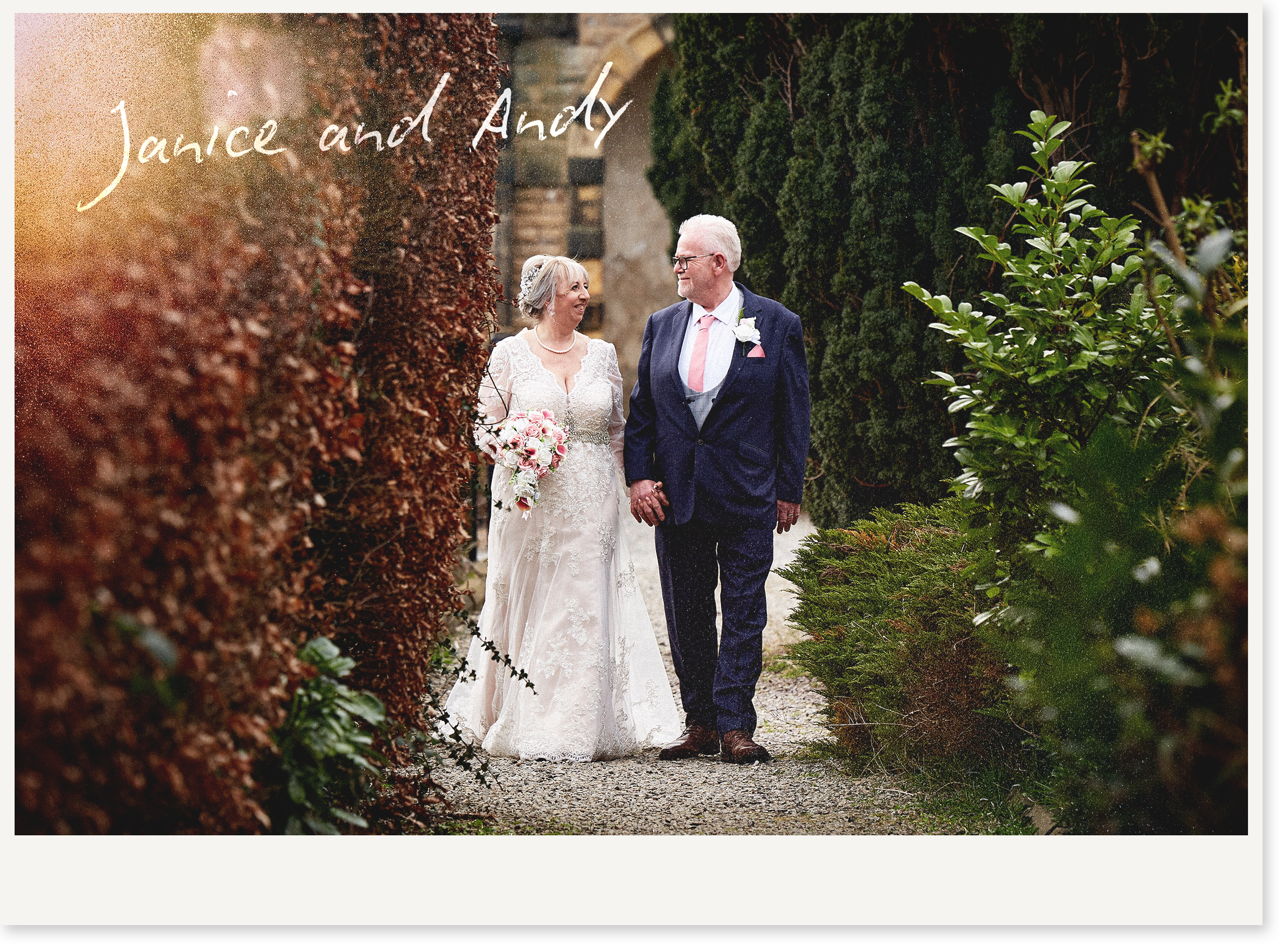 An elderly bride and groom are walking hand in hand in a lush garden, surrounded by green foliage and brown hedges, on their wedding day.