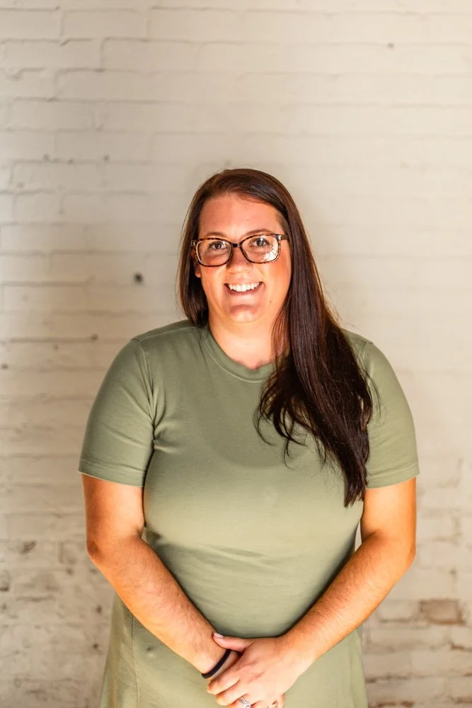 Headshot of Danielle Wallin in front of a white brick wall