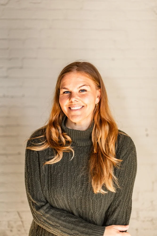 Headshot of Laura Warner in front of a white brick wall