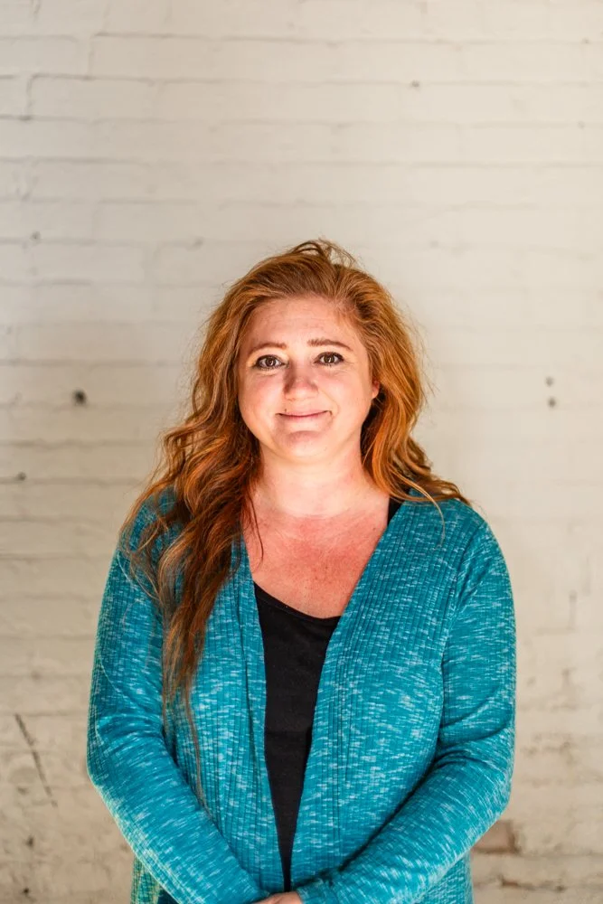 Headshot of Josie Sweitzer standing in front of a white brick wall