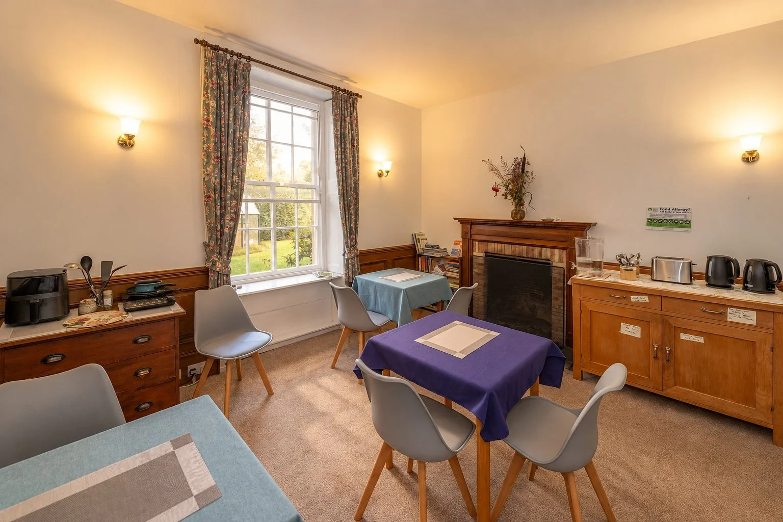 Gathering Room at Cullerne House in Findhorn, shown with breakfast tables and tea-making facilities.