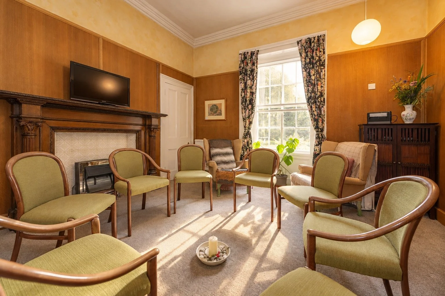 Chairs arranged in a circle in the wood-panelled Studio Room at Cullerne House in Findhorn.
