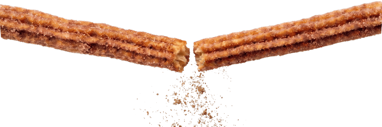 Close-up of a freshly fried, cinnamon-sugar churro being snapped in half at Que Churro in San Benito, Texas.